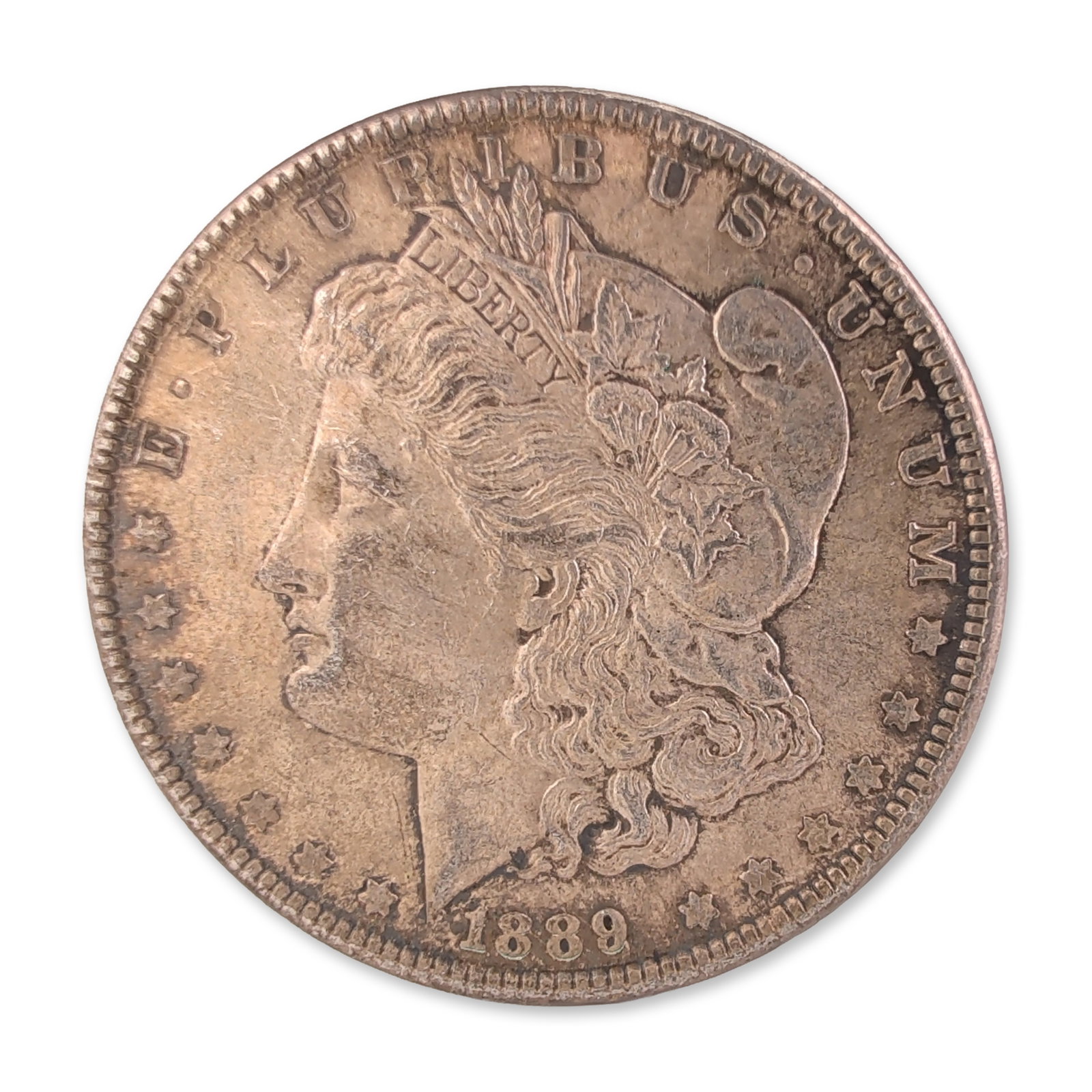 1889 US Morgan One Dollar Silver Coin, Circulated: US 1889 Morgan silver dollar struck at the Philadelphia Mint. Composed of 90% silver and 10% copper. The obverse features the left-facing profile of Liberty after the design by George T. Morgan, dated