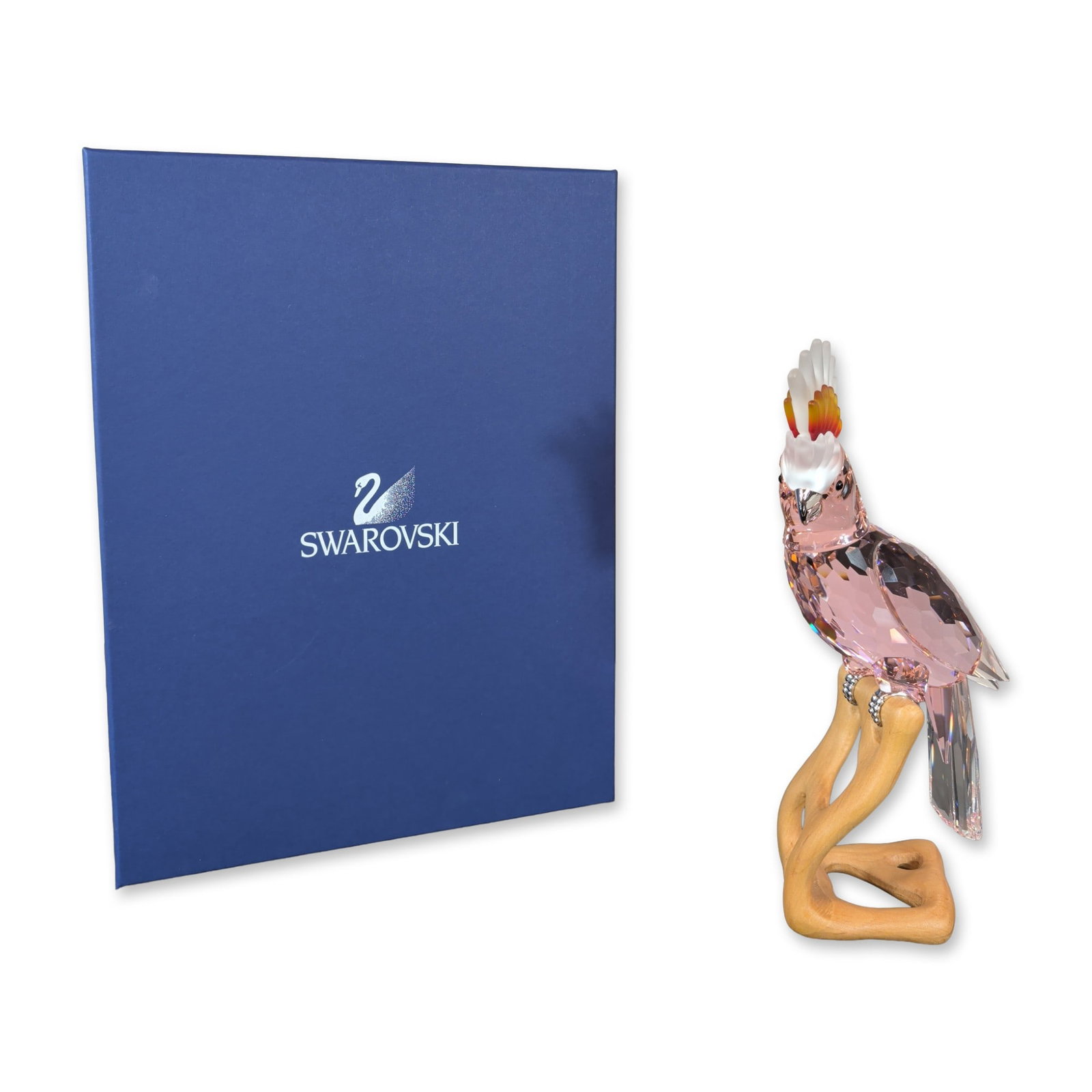Swarovski Paradise Collection Crystal Pink Cockatoo: Swarovski Paradise collection. Figurine depicting a cockatoo crafted in faceted Rosaline pink crystal. The bird features a multi-colored crest in graduated shades of yellow, orange, and red, with clea