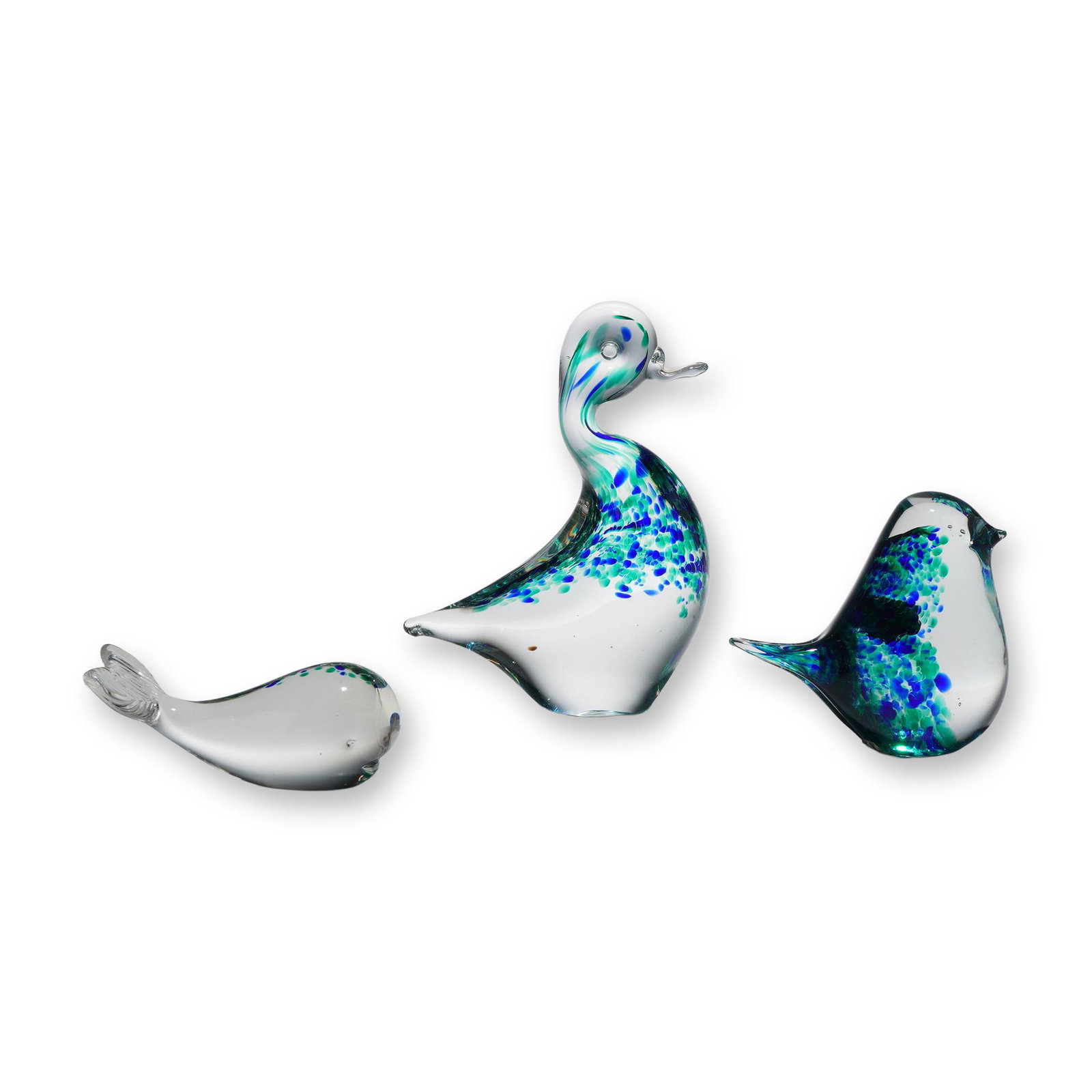 Three Wedgwood Glass Animal Paperweights Including Duck, Bird, and Whale: A collection of three hand-blown glass animal figurines produced by Wedgwood Glass in England. The group consists of a stylized duck with an elongated neck, a songbird, and a whale in a swimming pose.