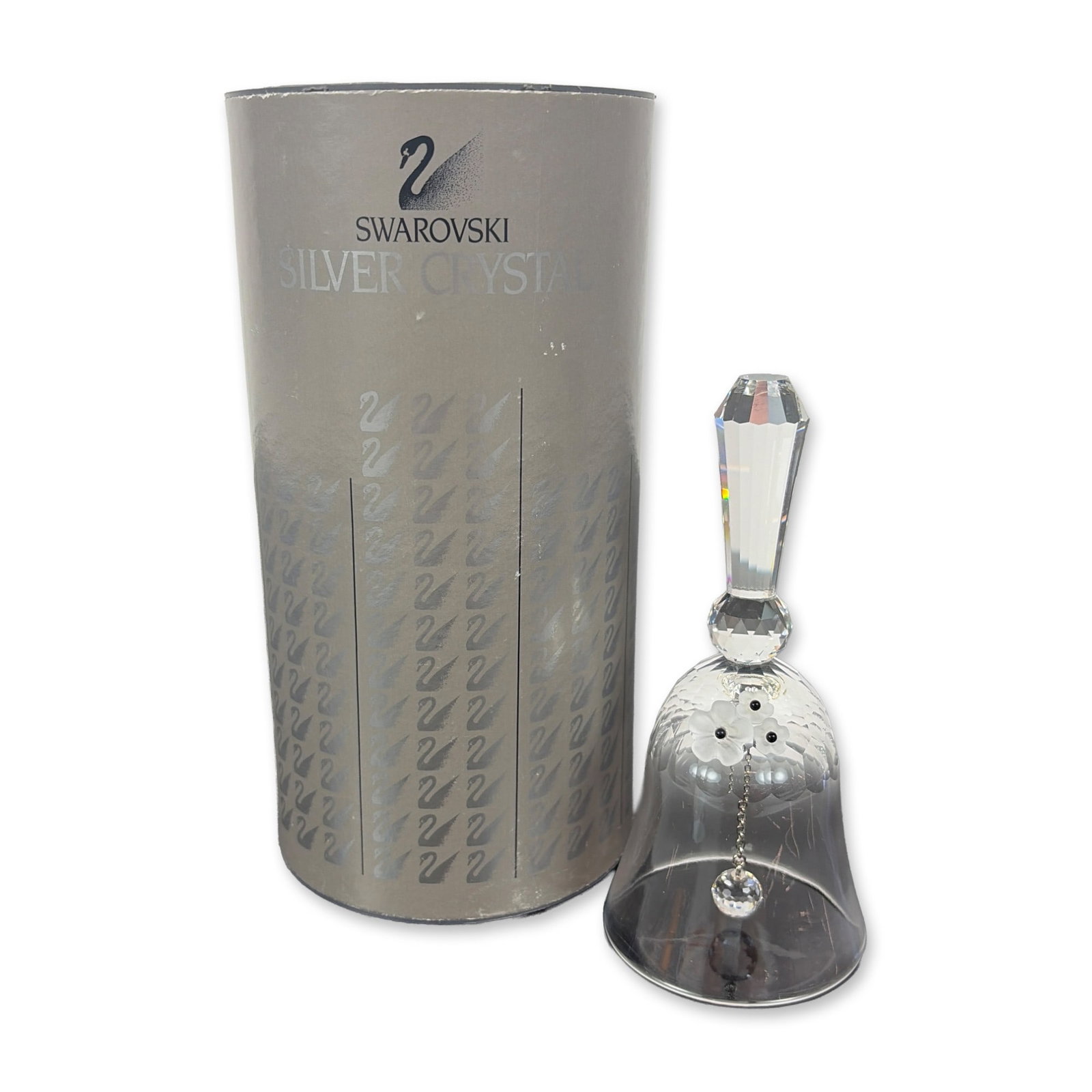 Swarovski Silver Crystal Medium Dinner Bell: The piece features a multi-faceted handle and a faceted crystal clapper suspended from a silver-tone metal chain. Includes the original cylindrical cardboard packaging. The crystal bell bears an etche