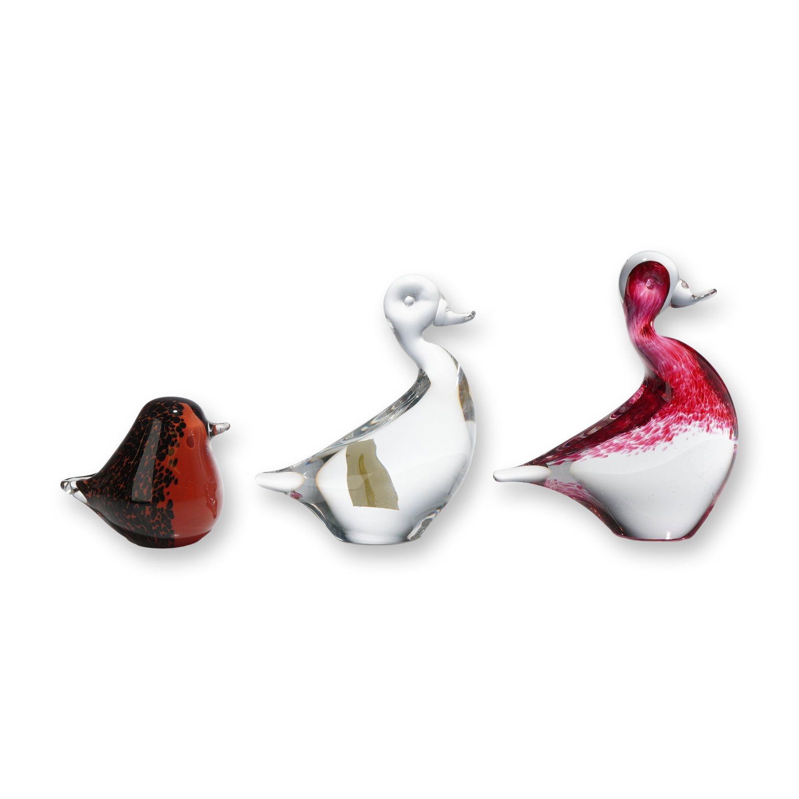 A Trio of Glass Bird Figurines: This set of three glass bird figurines includes a piece by Wedgwood Glass, England. The collection features three distinct stylized forms: a small rounded bird and two larger long-necked waterfowl. Th