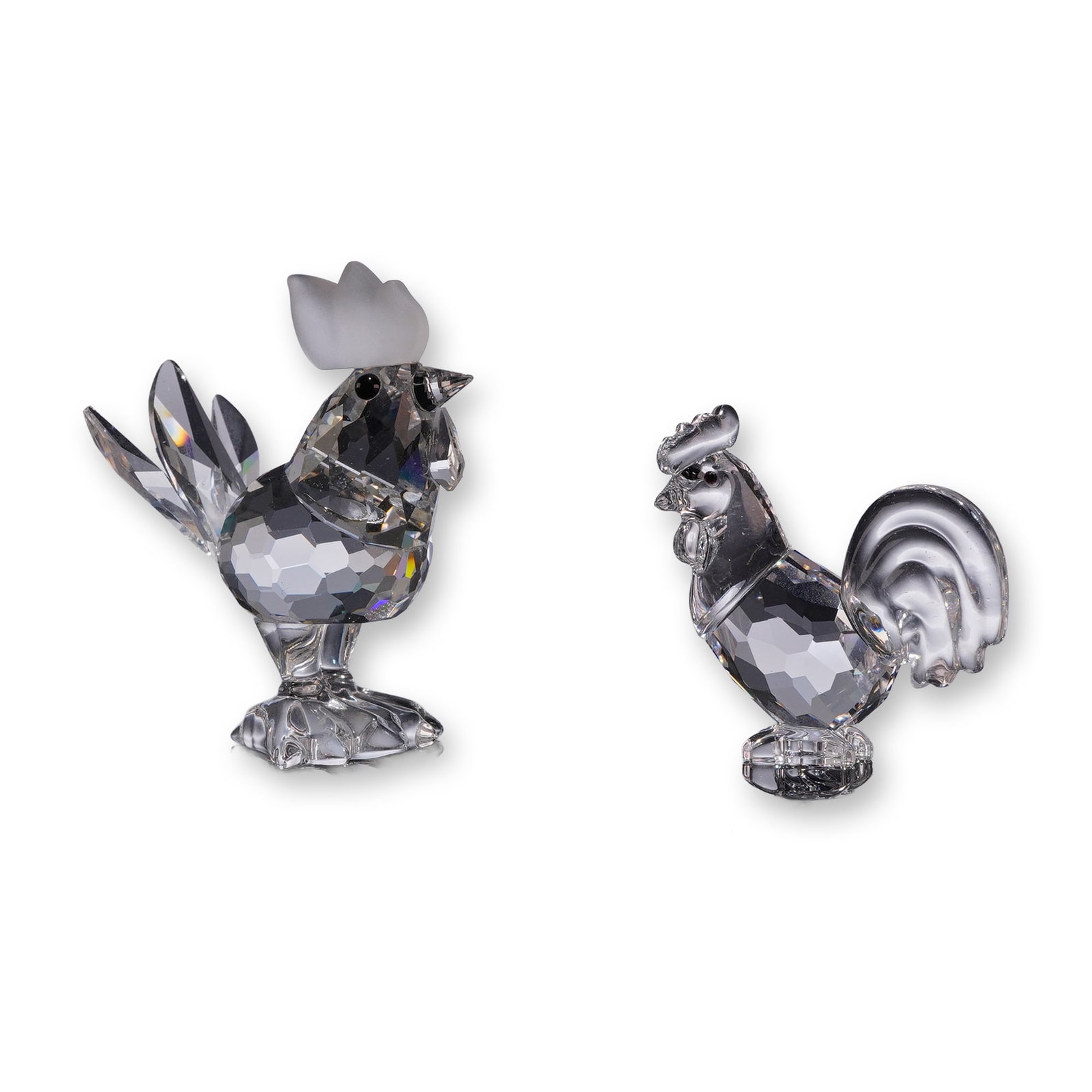 Two Swarovski Crystal Rooster Figurines: Swarovski, Austria. Two faceted lead crystal bird figurines, comprising the Cockerel, model 014497, and the Zodiac Rooster, model 625189. The Cockerel features a frosted crystal comb, black crystal ey