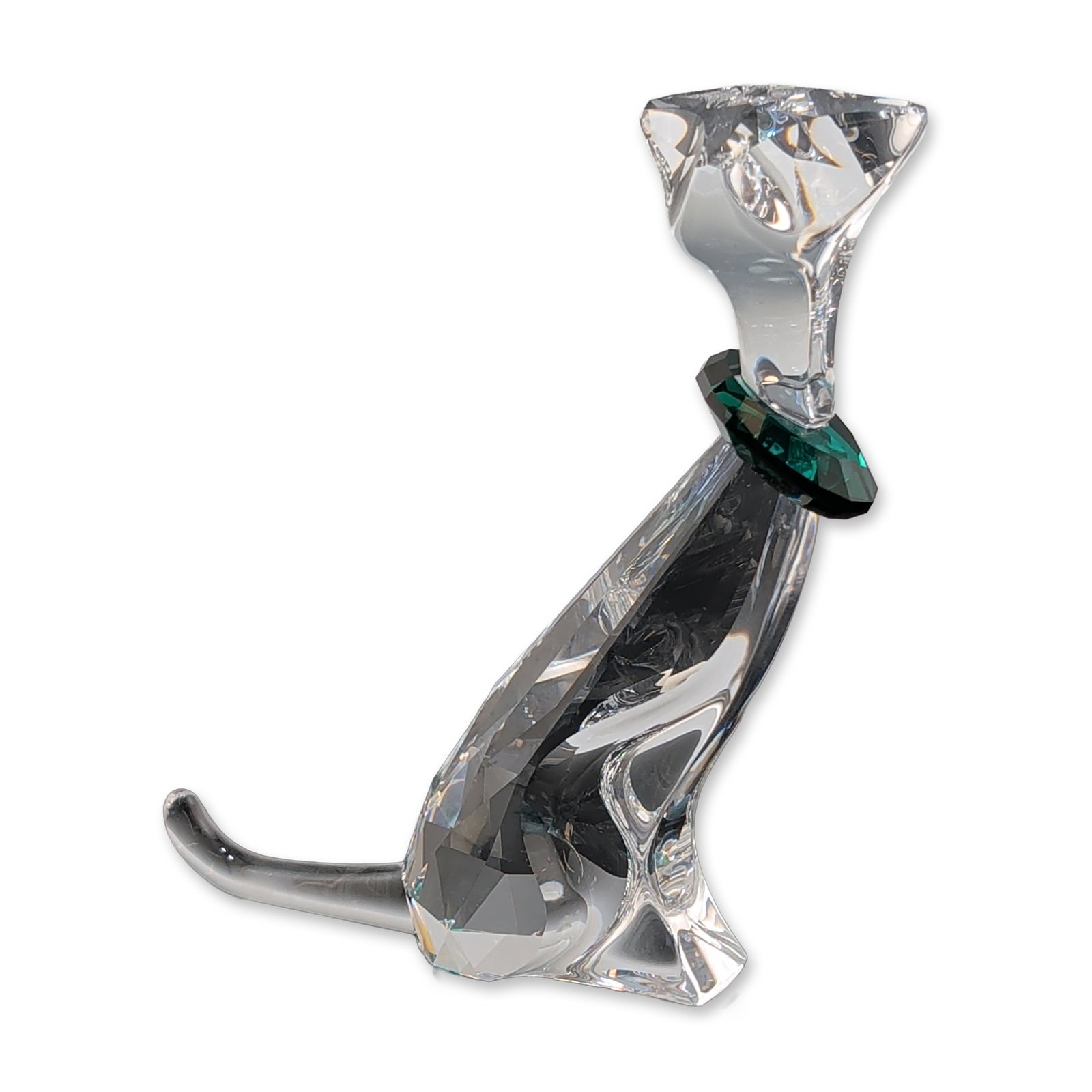 Swarovski Crystal Symbol The Cat Figurine: Swarovski faceted lead crystal figurine depicting a stylized seated cat, featuring an elongated neck and tail with a contrasting faceted emerald green crystal collar. Etched with the Swarovski swan lo