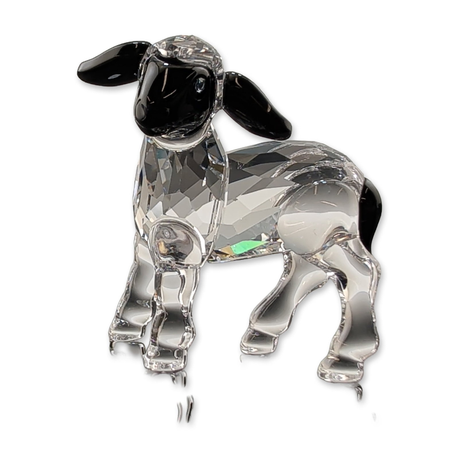 Swarovski Crystal Black Head Lamb Figurine: Swarovski crystal figurine depicting a little lamb with black markings. The piece is constructed from faceted clear lead crystal with jet black crystal accents at the face, ears and tail. The