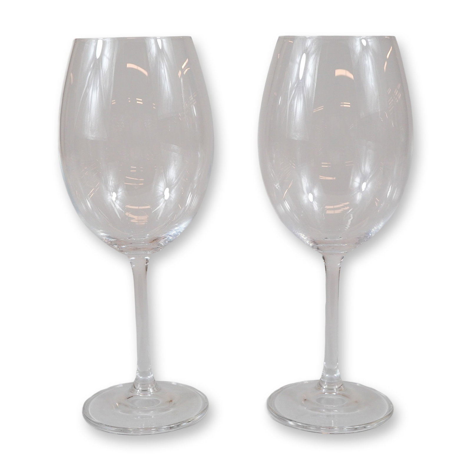 A Pair of Mikasa Crystal Large Wine Glasses: A pair of Mikasa clear crystal wine glasses. Each glass features a large, rounded bowl that tapers slightly toward the rim, supported by a long, slender stem and a flat, circular foot. The design is