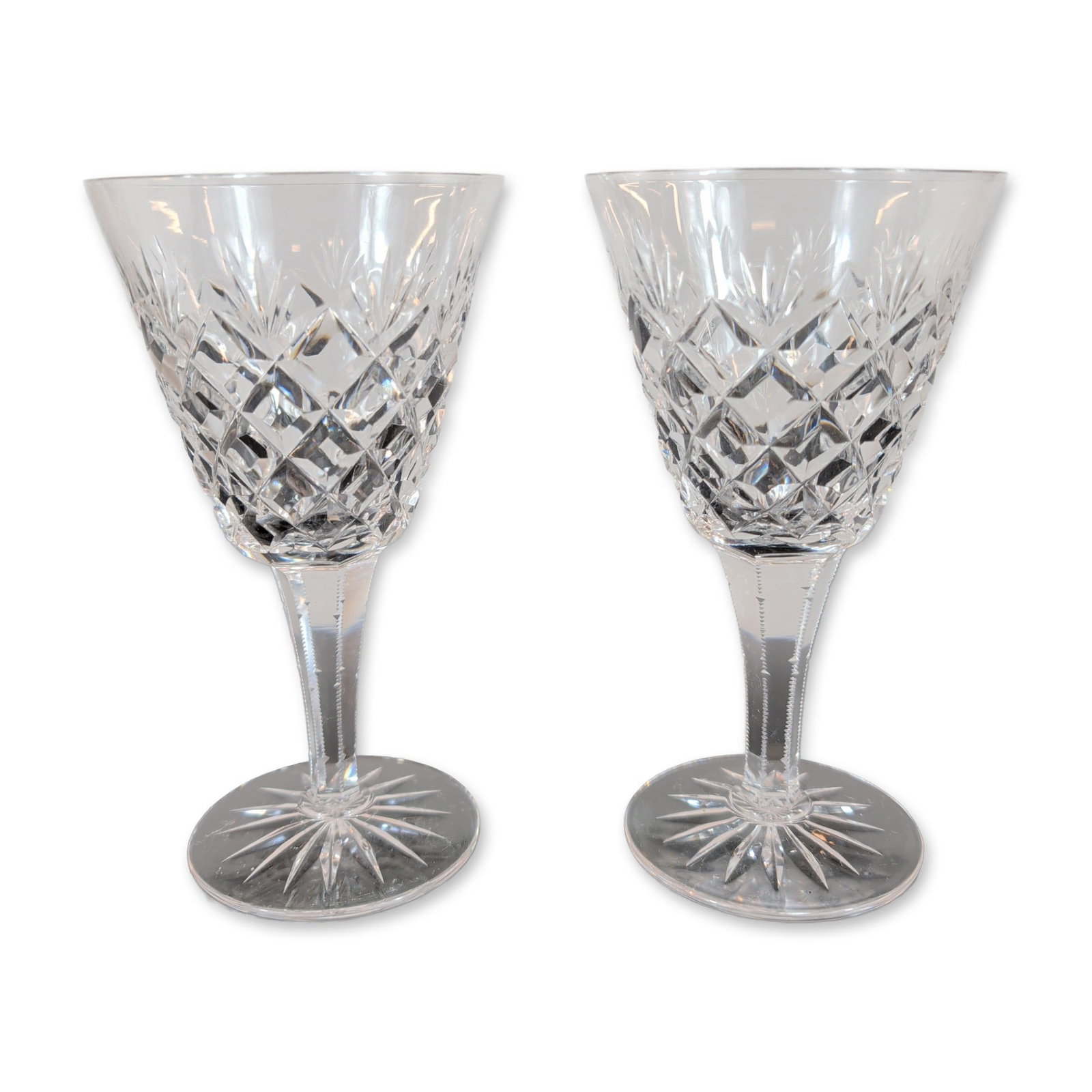 Pair of Crystal Wine Glasses: Pair of wine glasses in cut crystal, featuring a bowl with a diamond cut lower portion transitioning to vertical wedge cuts. The faceted stems display notched zipper cuts along the vertical edges,