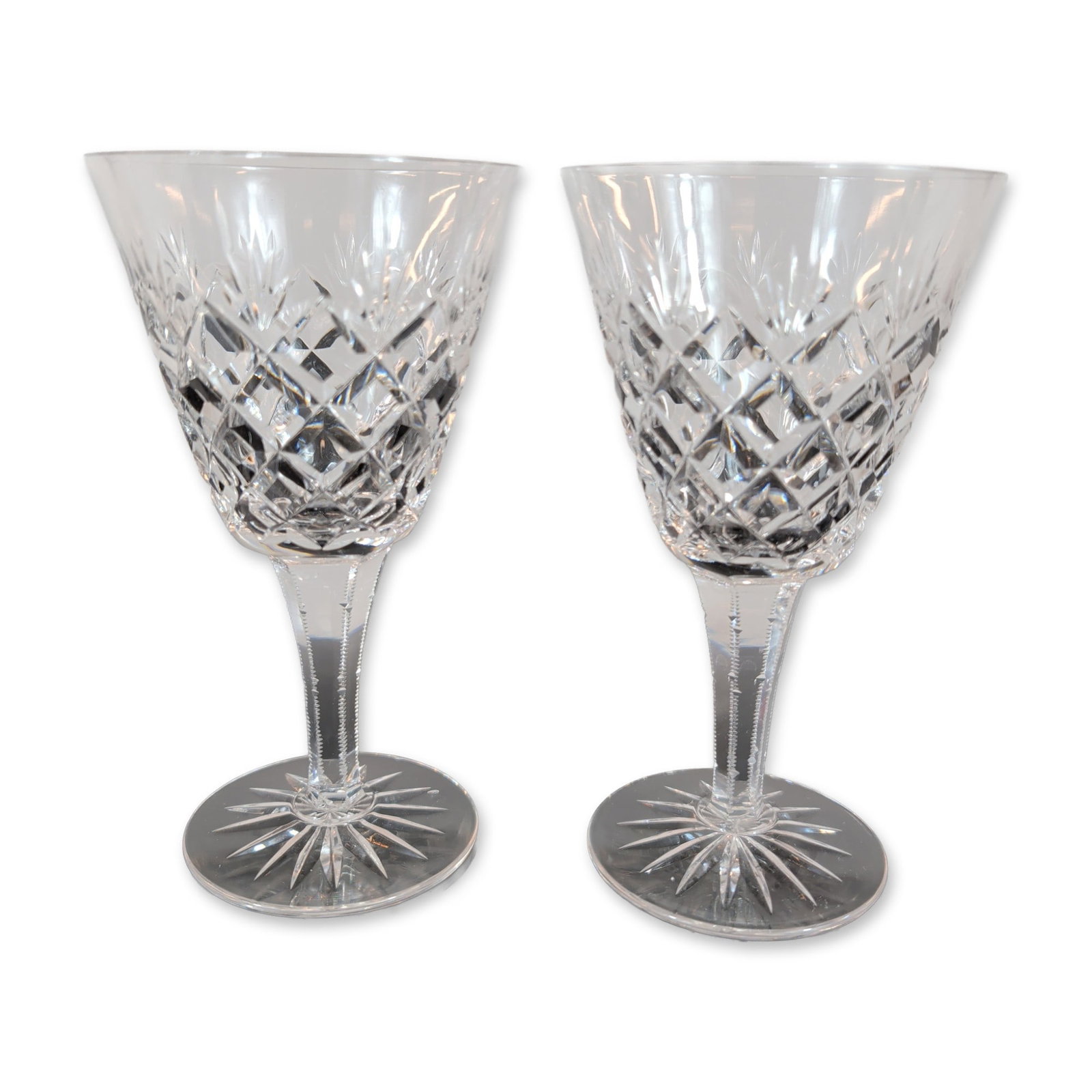 Pair of Cut Crystal Wine Glasses: Pair of lead crystal wine glasses. The bowls feature deep diamond cross-hatch cutting below a border of vertical wedge cuts. Each glass is supported by a faceted hexagonal stem with notched edges, ter