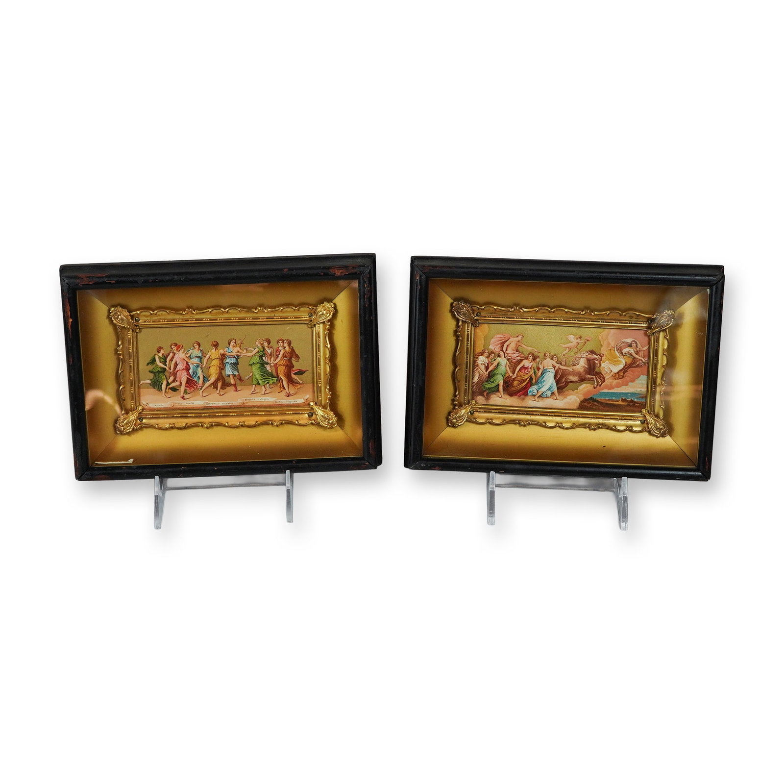 2pc Neoclassical Chromolithographic Prints on Gilt Paper in Shadow Box Frames: This pair of chromolithographic prints features neoclassical mythological subjects rendered on gold-toned paper. One print depicts the Nine Muses dancing in a ring, with a banner below inscribed with