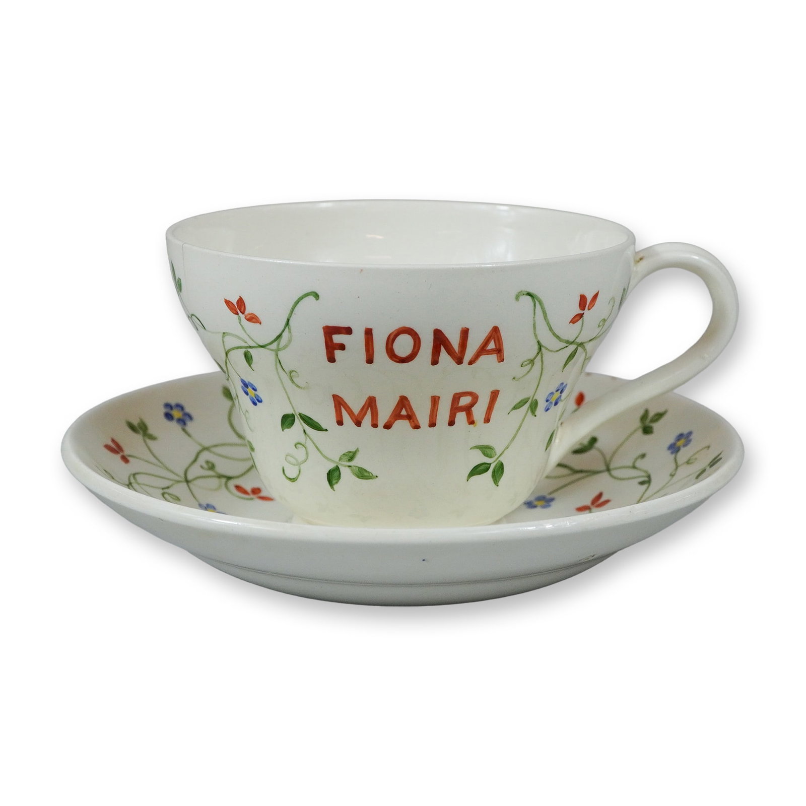 2pc Wedgwood Hand Painted Floral Tea Cup and Saucer Set by Millicent J. Taplin: A hand painted earthenware tea cup and saucer set manufactured by Wedgwood and decorated by Millicent J. Taplin. The set is crafted from cream colored Queen's Ware and features a delicate hand painted