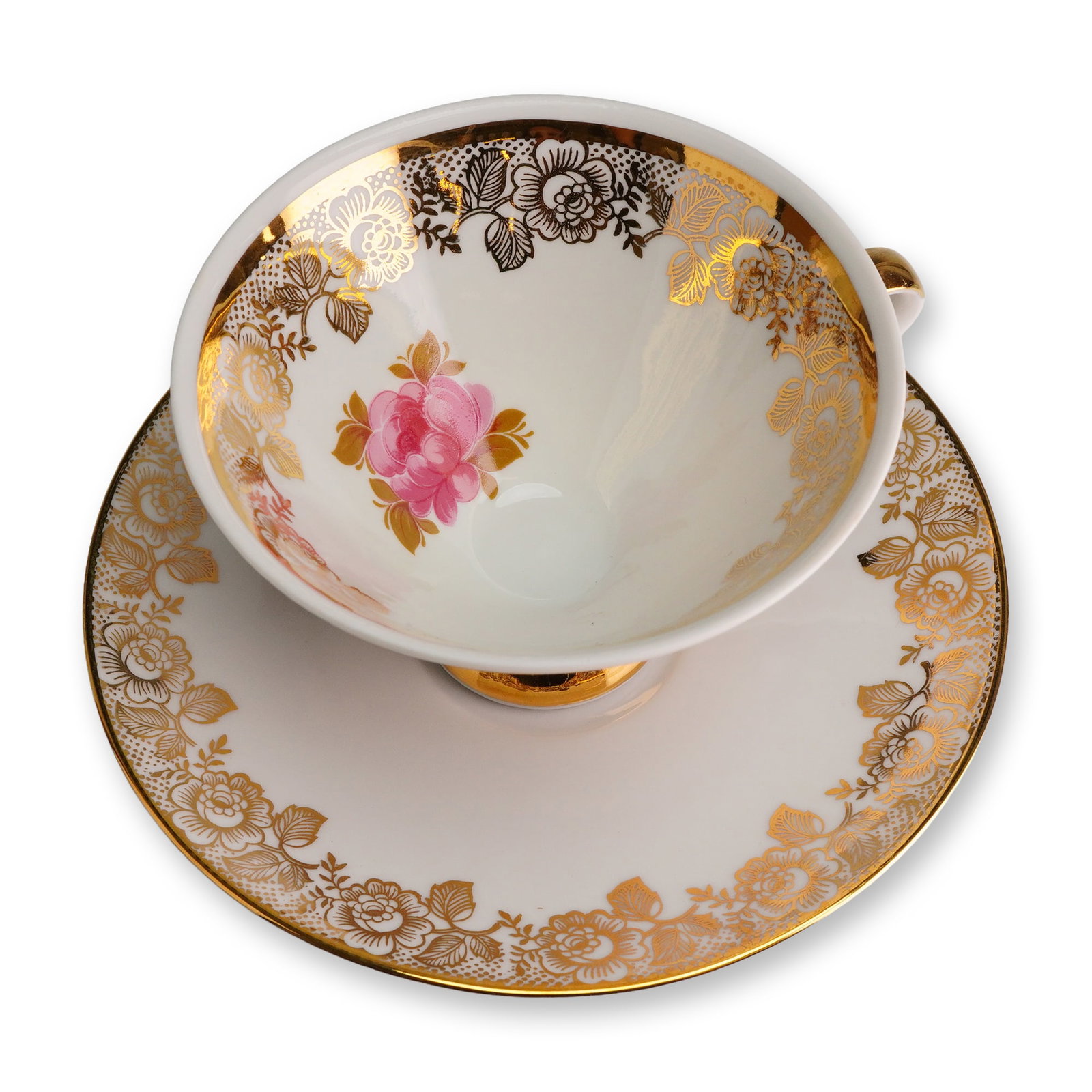 Mitterteich Bavaria Gilt Porcelain Tea Cup and Saucer: The set is constructed of white porcelain and features extensive gold transfer printing decoration. The teacup has a deep bowl shape resting upon a raised pedestal foot, with both the foot and the sim