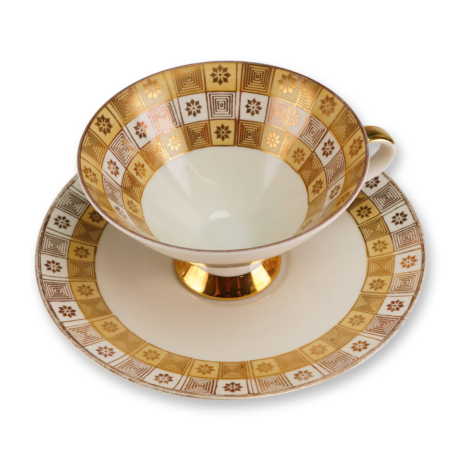 2pc Mitterteich Bavaria Porcelain Tea Set, Geometric Gilt: A 2-piece cup and saucer set executed in porcelain with heavy gold gilt accents. The set exhibits a Mid-Century modern style decoration characterized by a wide band of bold geometric patterns over a c