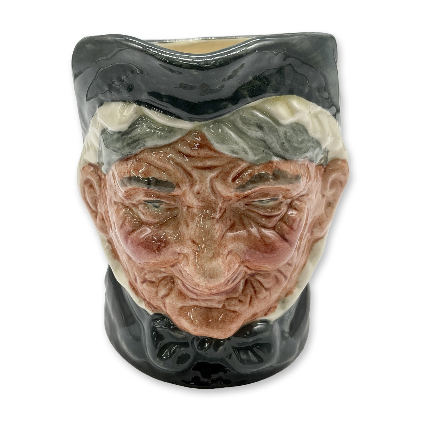 Granny D6384 - Small - Royal Doulton Character Jug: Style One, Toothless Granny. Dark green and white coloration. Royal Doulton backstamp. Artist: Harry Fenton Dimensions: 3.25"H Date or Era: 1935 Manufacturer or Brand: Royal Doulton Country of Ori