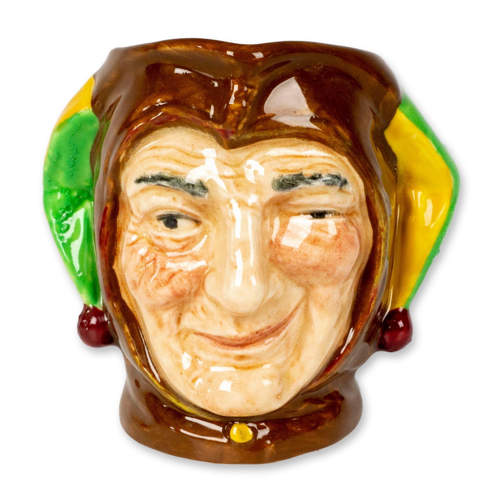 Jester D5556 - Small - Royal Doulton Character Jug: Souvenir From Bentalls backstamp. Features Jester in brown, yellow, and green coloration. Royal Doulton backstamp. Artist: Charles Noke Dimensions: 3.5"L x 4"W x 3.25"H Date or Era: 1936-1960 Manufact