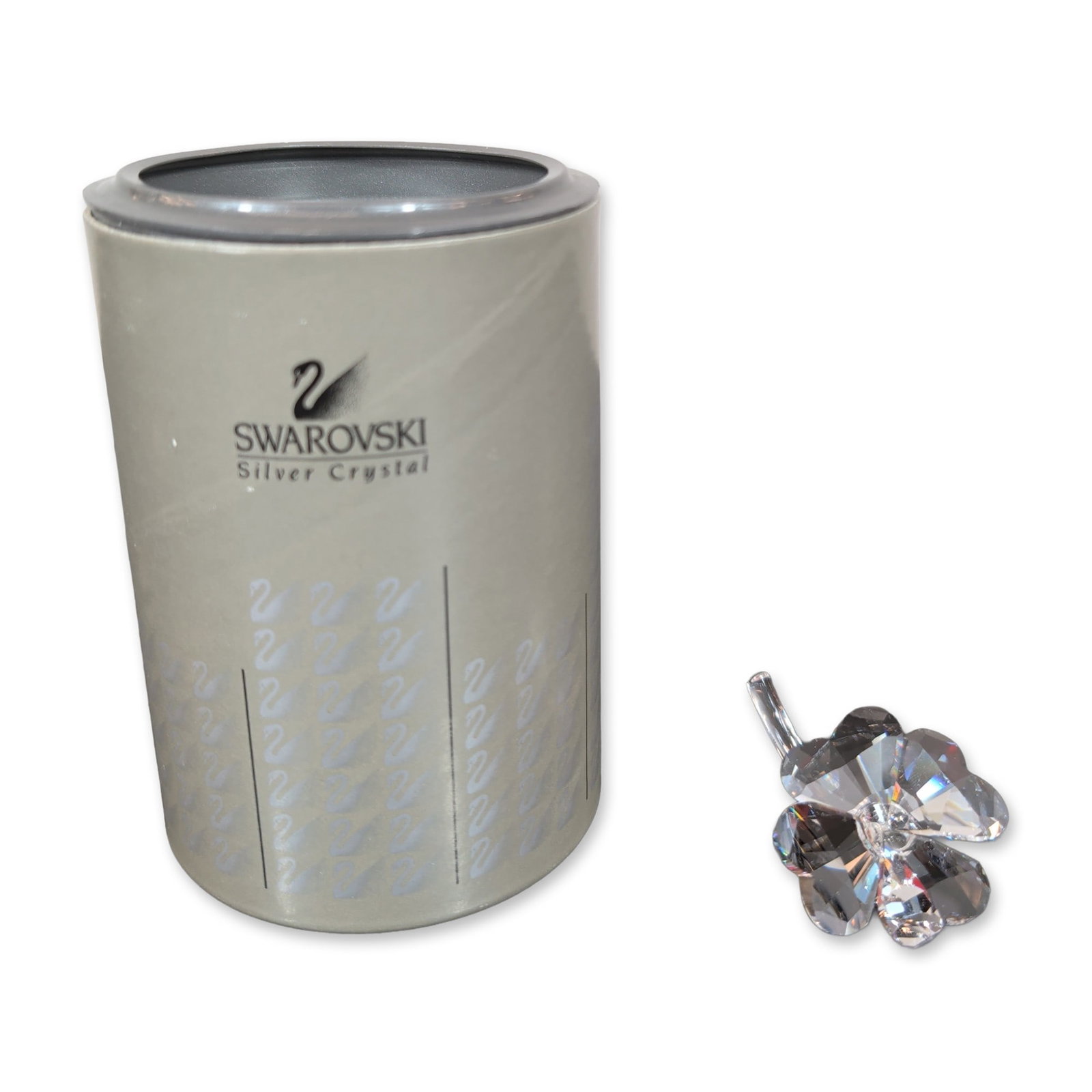 Swarovski Silver Crystal Four-Leaf Clover Figurine: Swarovski Silver Crystal four-leaf clover figurine in faceted clear lead crystal. The piece features four heart-shaped faceted leaves joined to a curved smooth crystal stem. The underside of one leaf 