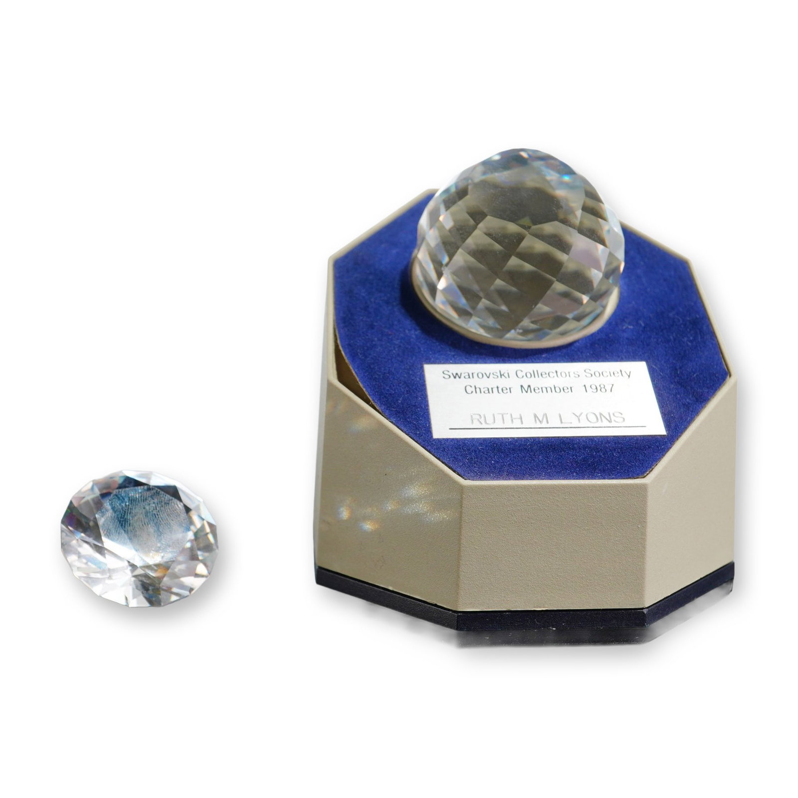 2pc Swarovski 1987 Crystal Society Commemorative Set: 1987 Swarovski Collectors Society. Two-piece set in faceted clear crystal, including a prismatic sphere paperweight with black felt base and a separate chaton-cut decorative stone. The items are prese