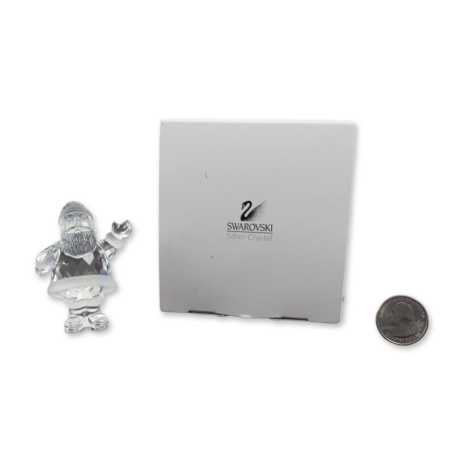 Swarovski Silver Crystal Santa Claus Figurine: Swarovski Santa Claus figurine crafted in faceted and frosted lead crystal from the Exquisite Accents series. Designed in a waving pose, it features a faceted crystal body with frosted crystal accents