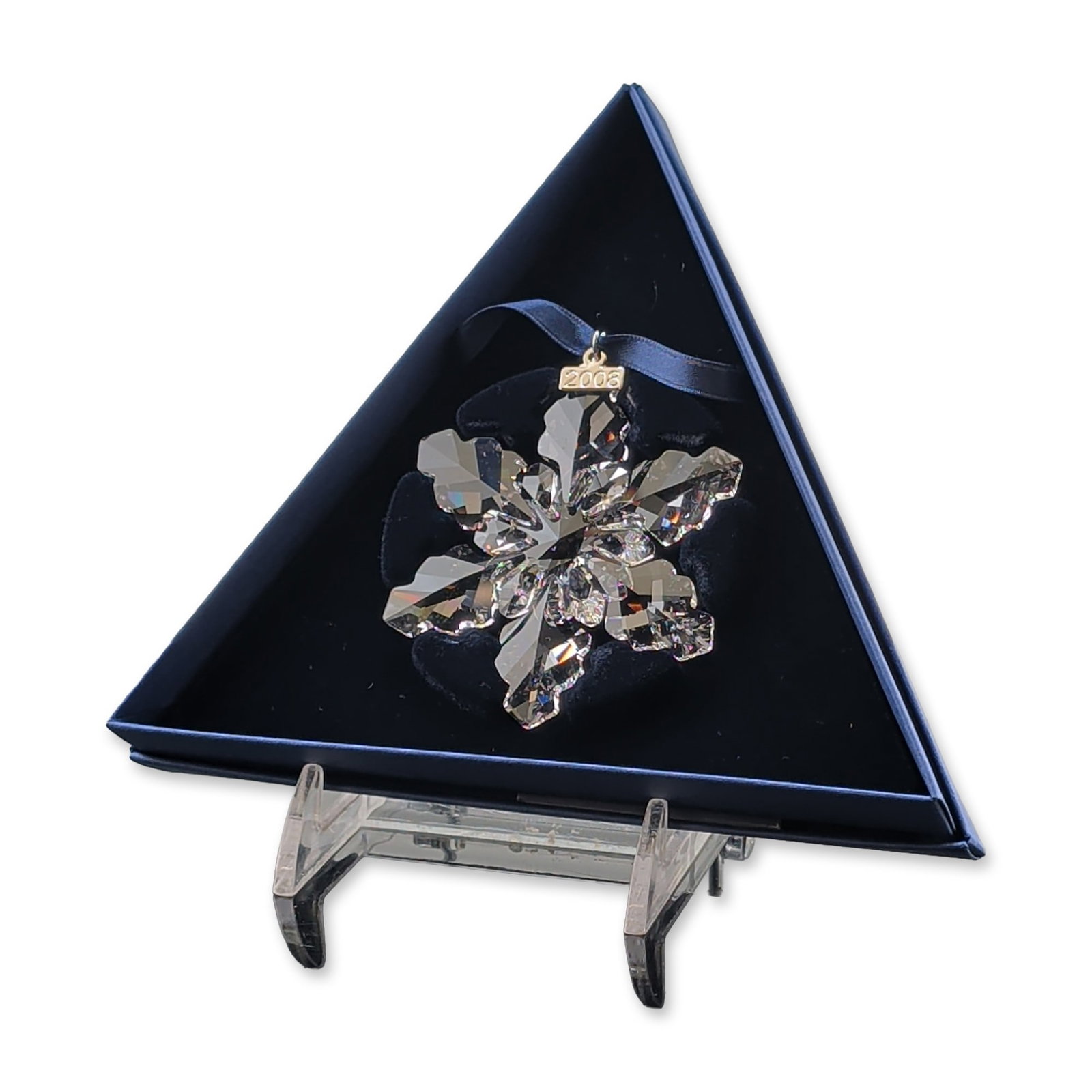 Swarovski 2008 Annual Edition Crystal Snowflake Ornament: Swarovski Annual Edition 2008 Christmas ornament in faceted clear lead crystal, featuring a complex six-pointed snowflake design with multiple geometric facets. The ornament is suspended from a blue s