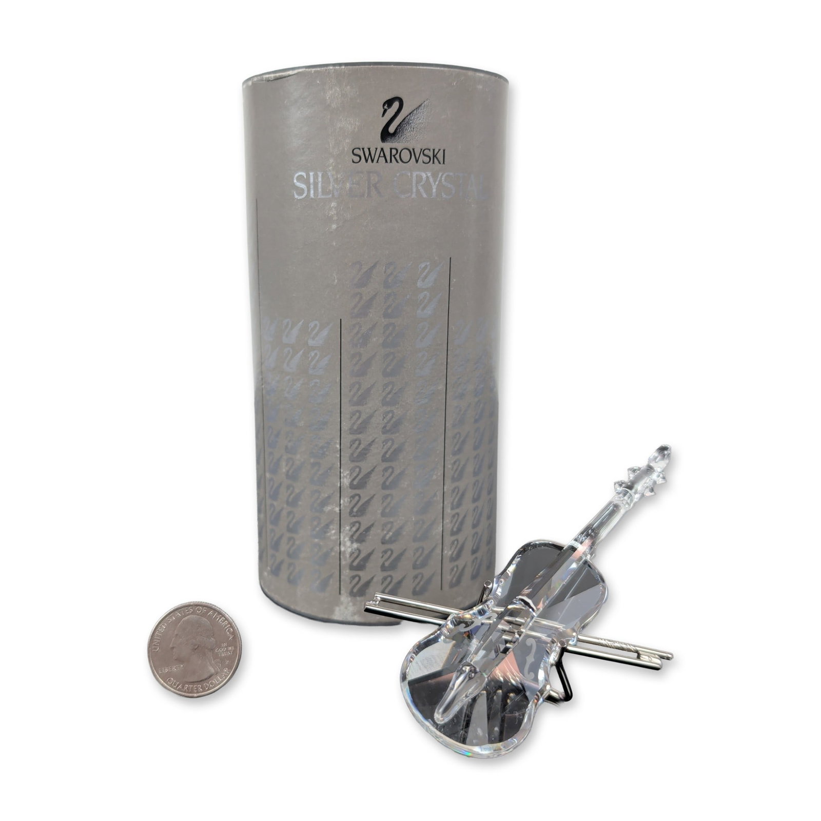 Swarovski Silver Crystal Violin Figurine: Swarovski model 7477 NR 002, in faceted clear lead crystal with This piece comes with rhodium metal bow and stand. Original cylindrical grey presentation box with repeating swan logo and manufacturer 