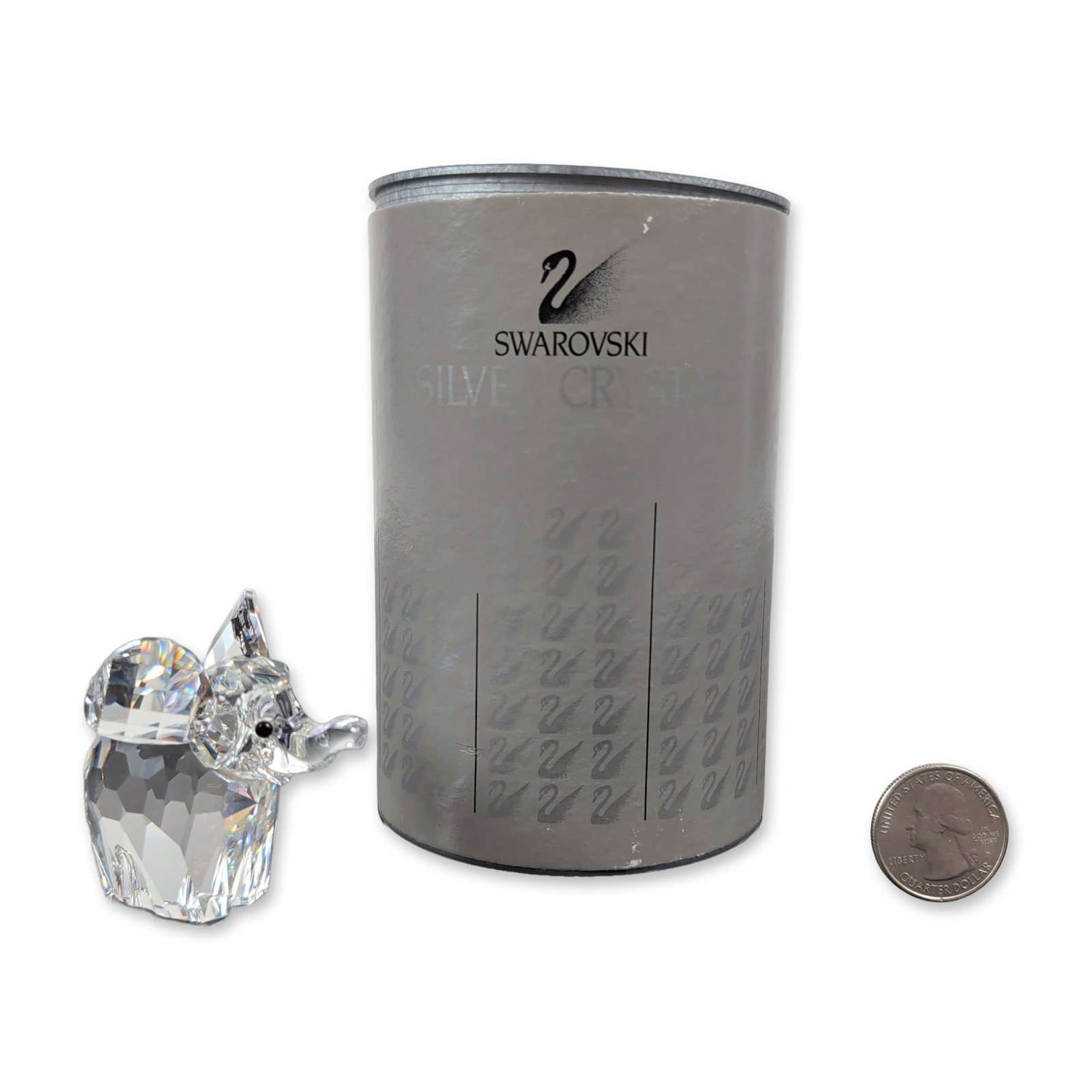 Swarovski Silver Crystal Elephant Figurine: This exquisite Austrian Swarovski Elephant figurine from the African Wildlife series is crafted in faceted clear lead crystal, showcasing striking black beaded eyes and a proudly raised trunk. The und