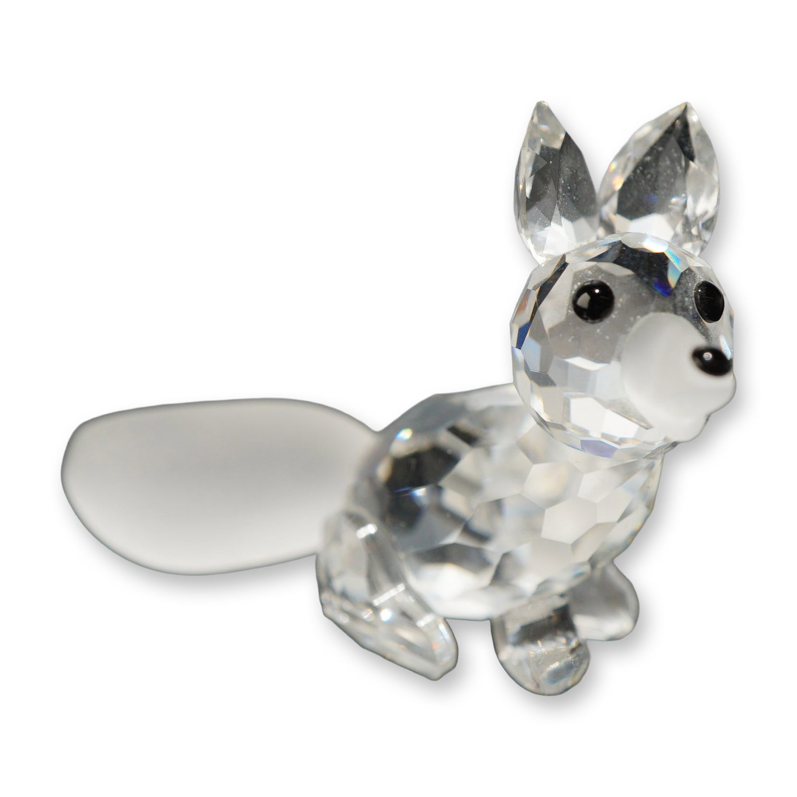 Swarovski Silver Crystal Sitting Fox Figurine: Swarovski Silver Crystal miniature sitting fox figurine. Constructed from faceted clear lead crystal with a faceted head, body, ears, and legs. Detailed with a frosted crystal muzzle, a long smooth fr