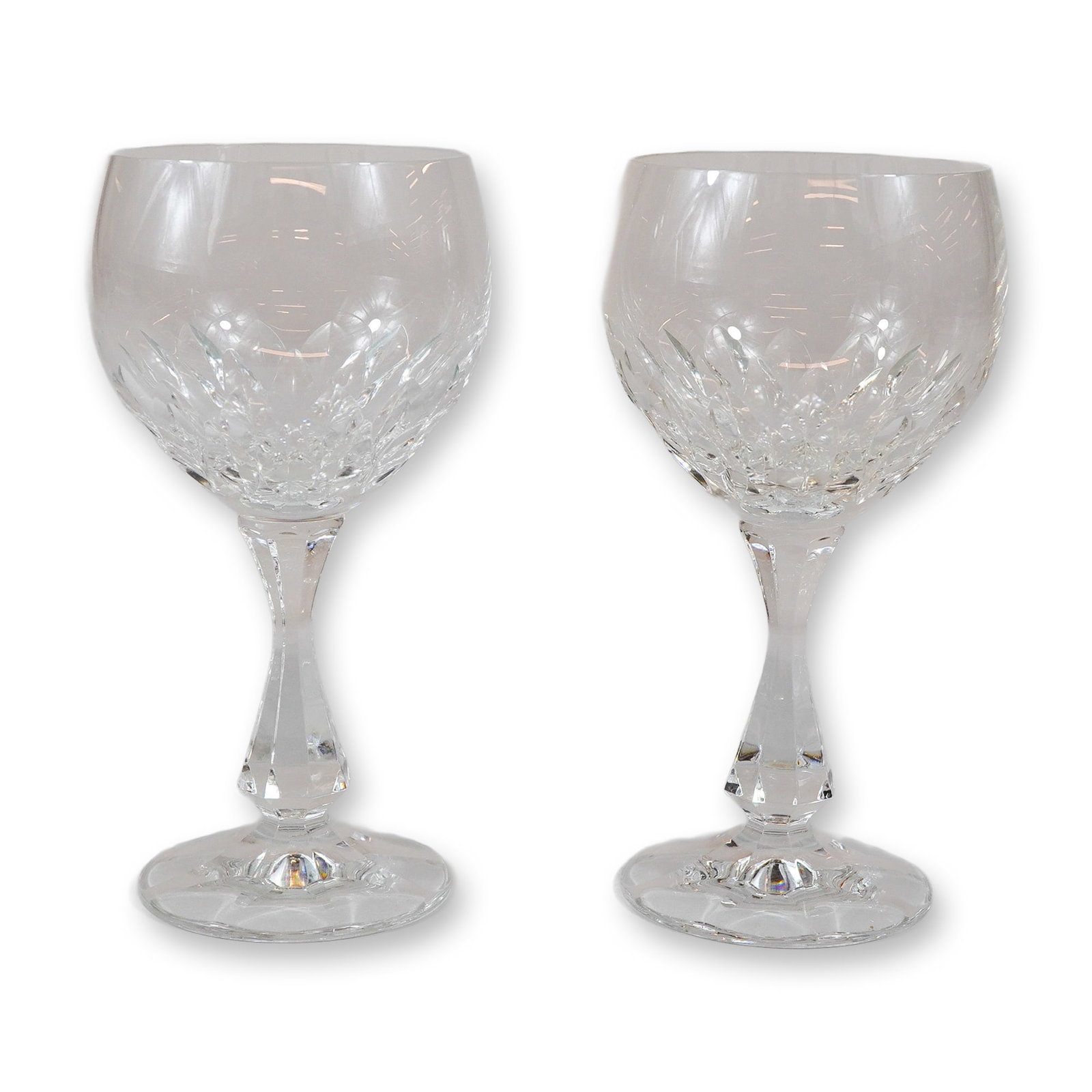 Pair of Cut Crystal Decorated Wine Glasses with Faceted Stems: A set of two matching wine glasses crafted from lead crystal. The bowls are designed with a clear upper portion and a decorative lower section featuring deep crisscross or diamond-shaped cuts. The gla