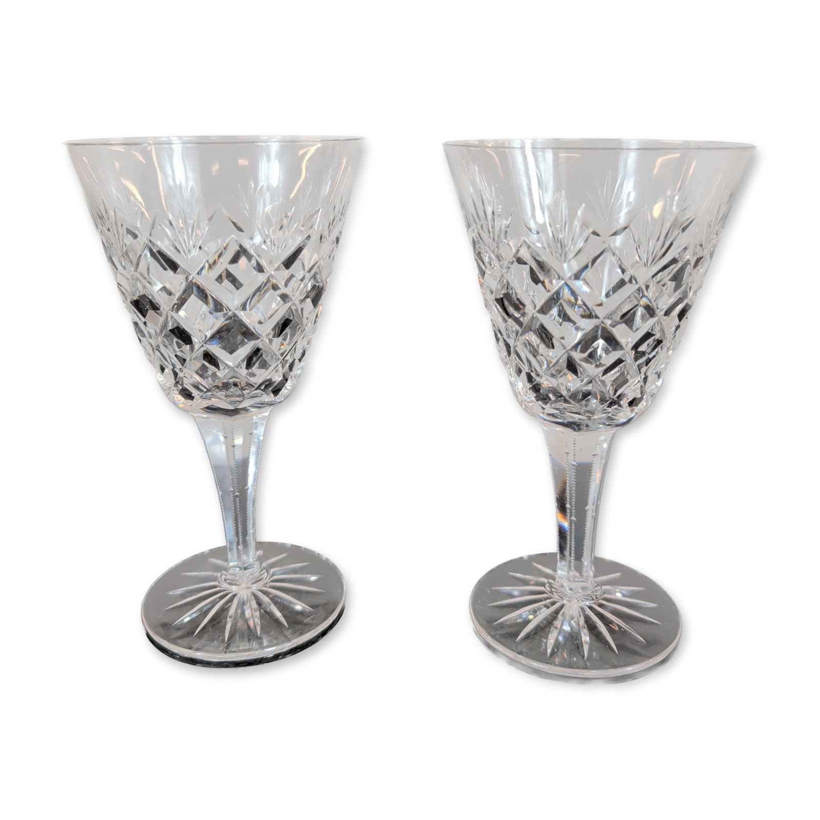 Pair of Cut Crystal Goblets: Pair of cut crystal goblets. Each vessel features a bell-shaped bowl with a diamond-cut lower register below vertical wedge cuts and a polished plain rim. The faceted hexagonal stem is decorated with