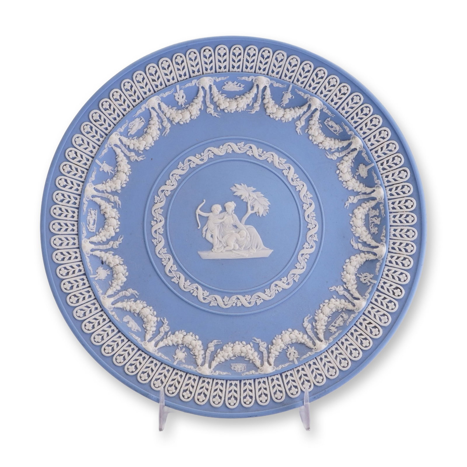 Wedgwood Blue Jasperware Plate: This jasperware plate is produced by Wedgwood, featuring a characteristic light blue unglazed stoneware body. The underside of the plate is marked with an impressed Wedgwood stamp. It also retains a