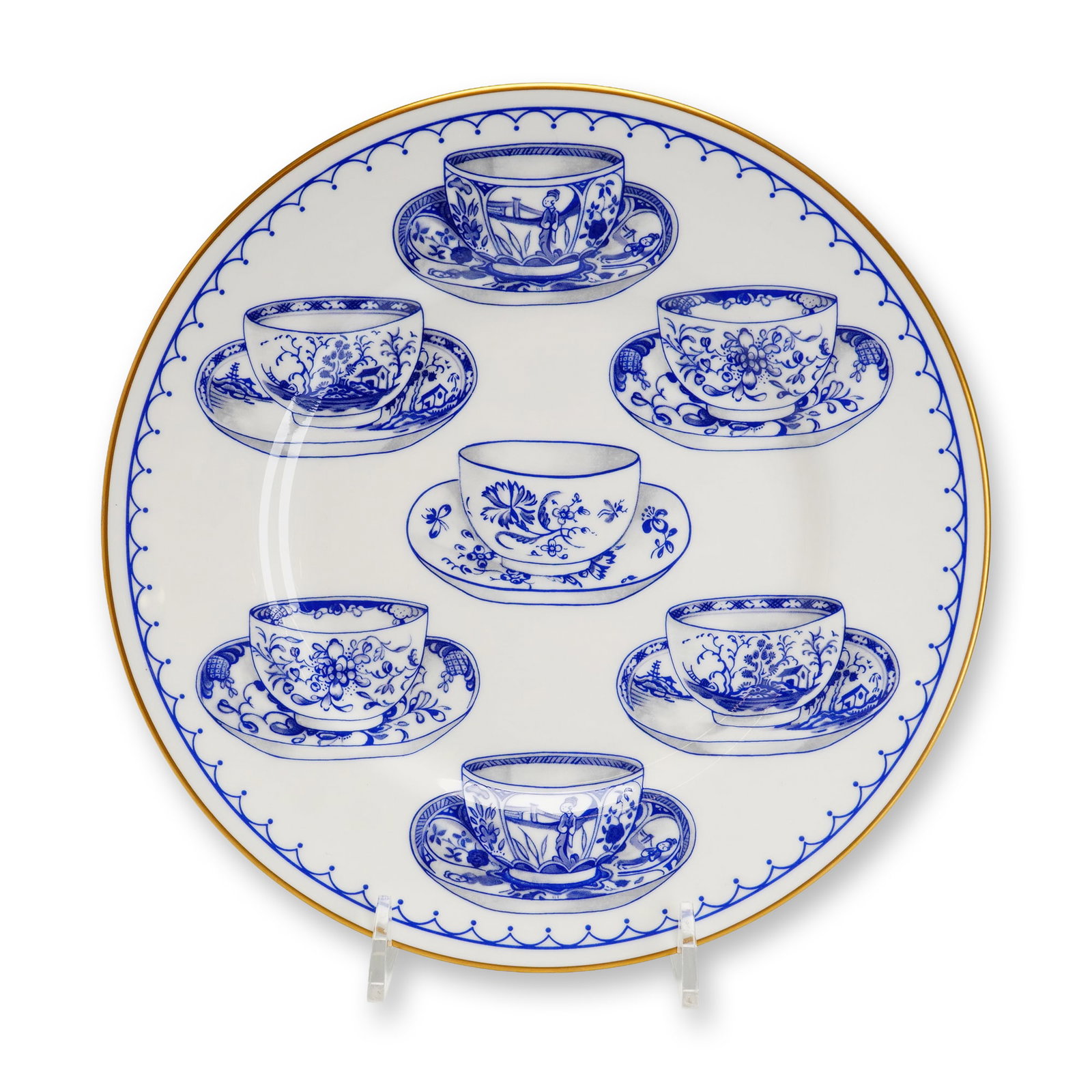 Royal Worcester Fine Bone China Plate, Cup of Cups: This Royal Worcester fine bone china circular display plate in the "Cup of Cups" pattern was manufactured in England in 1995. It features a white ground with a gilded rim and a blue scalloped outer bo