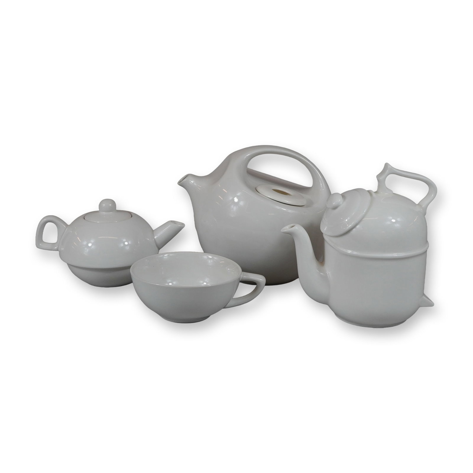 4pc Ronnefeldt White Porcelain Teapot Collection: This collection comprises three white porcelain teapots with lids and one bowl, executed in modernist and functionalist design styles. The first item is a Ronnefeldt Kippkanne tilting teapot designed 