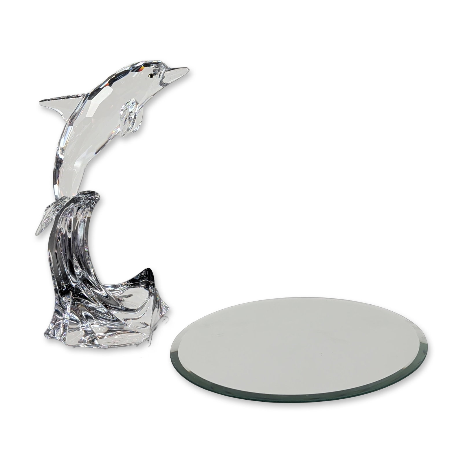 Swarovski Clear Crystal Dolphin Maxi on Wave Sculpture with Mirror Base: Swarovski crystal figurine depicting a dolphin leaping over a cresting wave. The dolphin is rendered in clear faceted crystal with polychrome eyes, while the wave base features fluid, molded crystal f