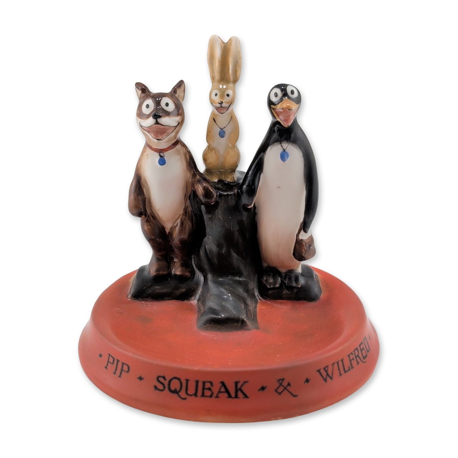 Royal Doulton Rare Pip, Squeak and Wilfred Ceramic Figural Group Pin Tray, Daily Mirror: Glazed ceramic figural group in the form of a pin tray, featuring Wilfred the rabbit, Squeak the penguin, and Pip the dog from the Daily Mirror comic strip. The characters are modeled wearing their si
