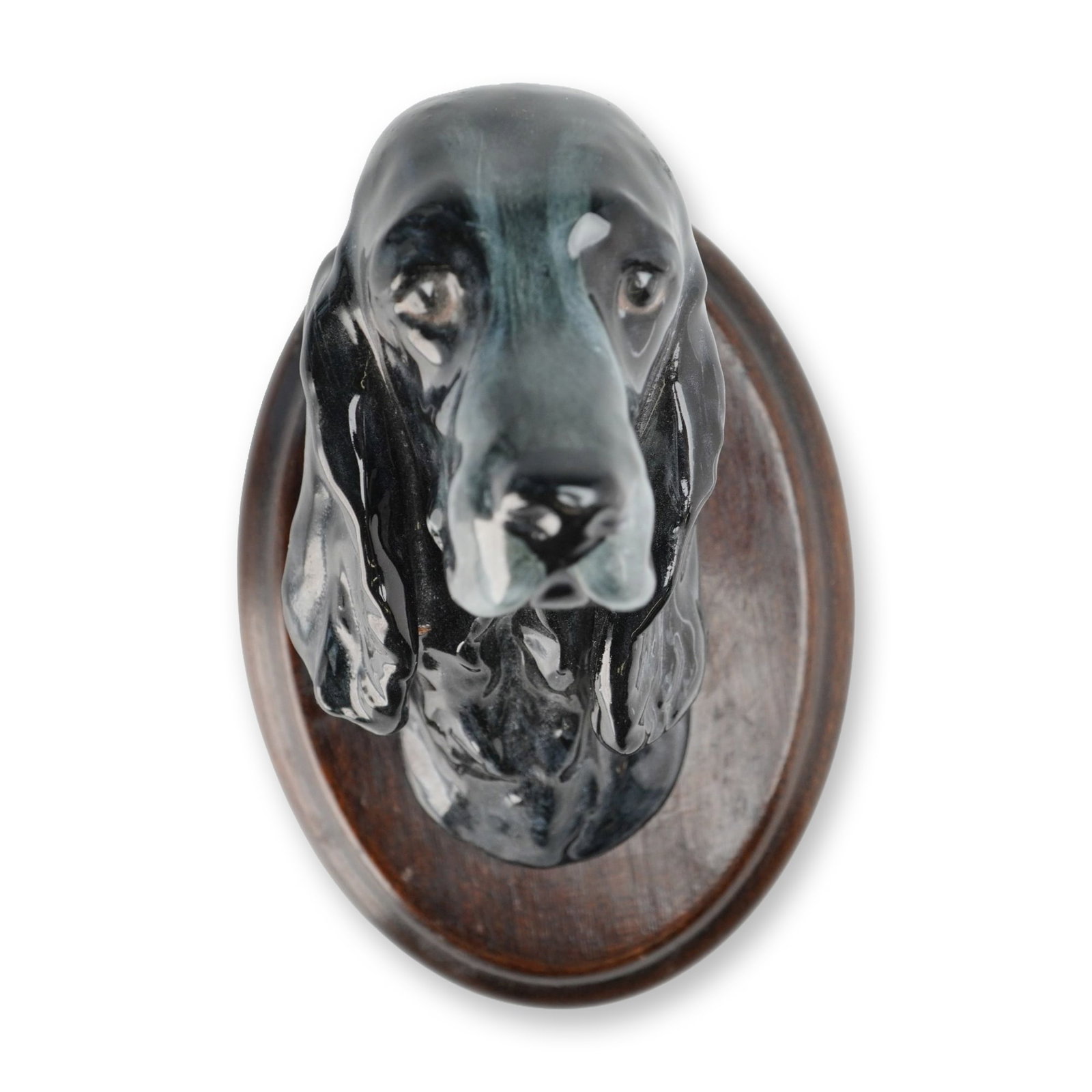 Royal Doulton Wall Mount, Cocker Spaniel Mount SK24: Depicting a Cocker Spaniel with long pendant ears. The three-dimensional ceramic bust is finished in a high-gloss, mottled black and slate-gray glaze. The bust is mounted on an oval, dark-stained wood