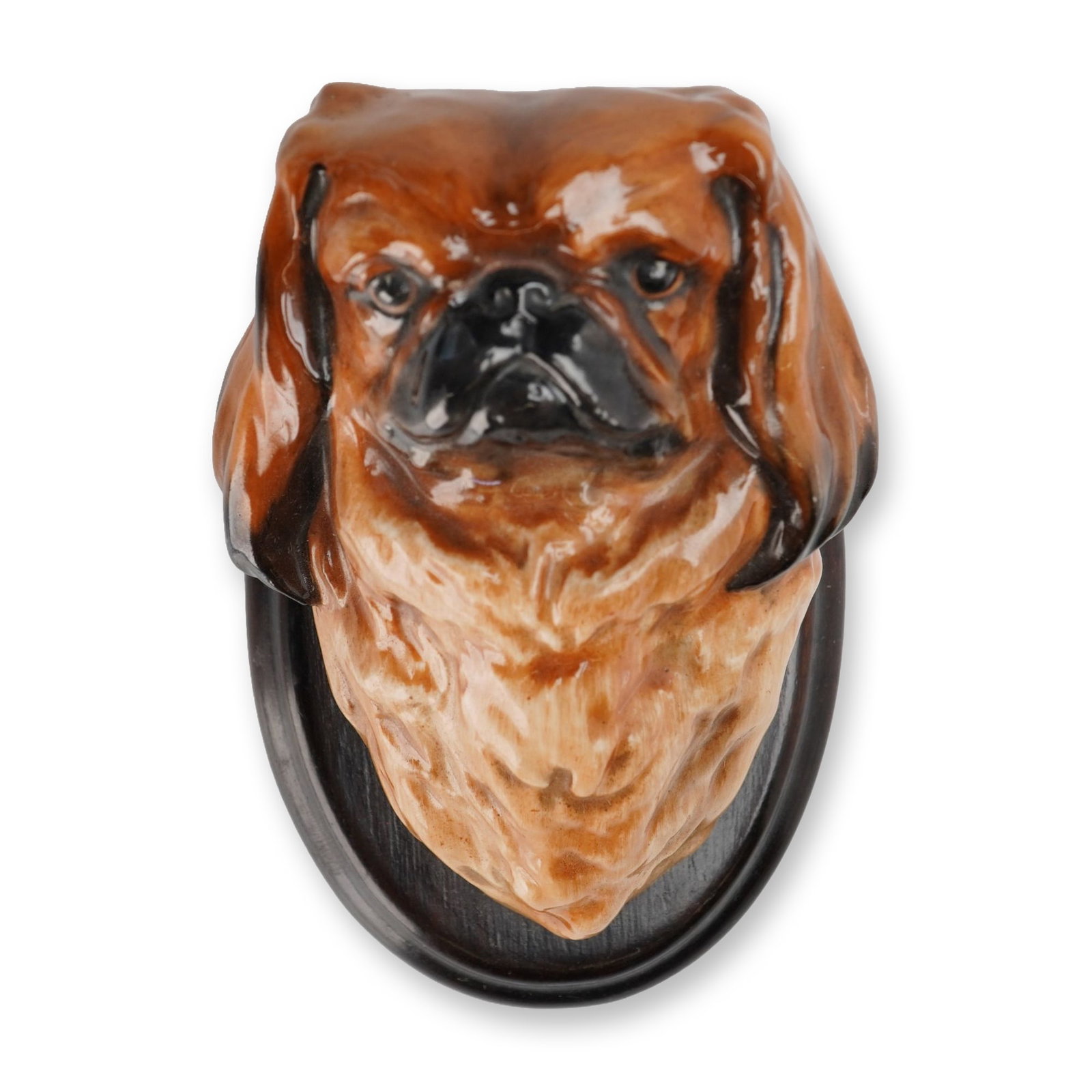 Royal Doulton Wall Mounts, Pekinese Mounted SK31: Glazed ceramic wall plaque depicting the head of a Pekingese dog. The three-dimensional dog bust features a glossy brown, tan, and black glaze, realistically capturing the characteristic flat muzzle, 