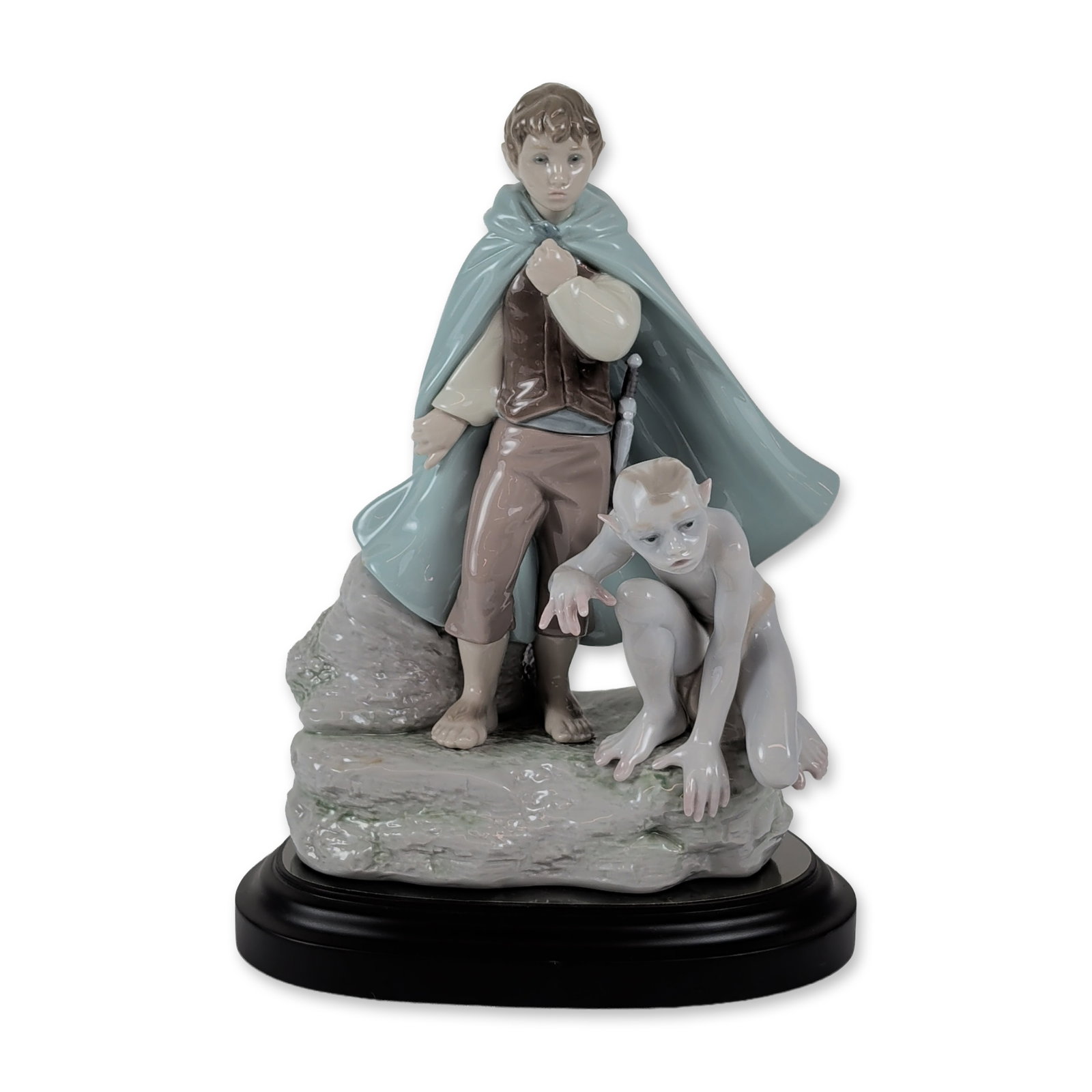 Lladro Limited Edition Frodo and Gollum Figurine: Lladro (Spain). Glazed porcelain figurine depicting Frodo Baggins and Gollum from The Lord of the Rings, featuring Frodo in a traveling cloak with the hilt of his sword visible and Gollum in a charact