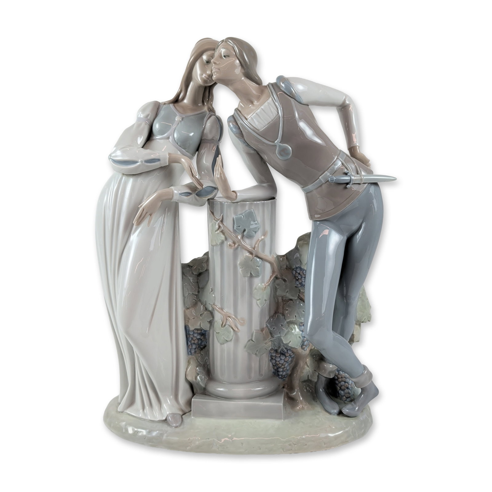 Lladro Romeo and Juliet Porcelain Sculpture: Lladro, Spain. Large, glazed porcelain figurine titled Romeo and Juliet, model number 4750. The romantic scene features two figures in Renaissance-style clothing arranged around a fluted classical