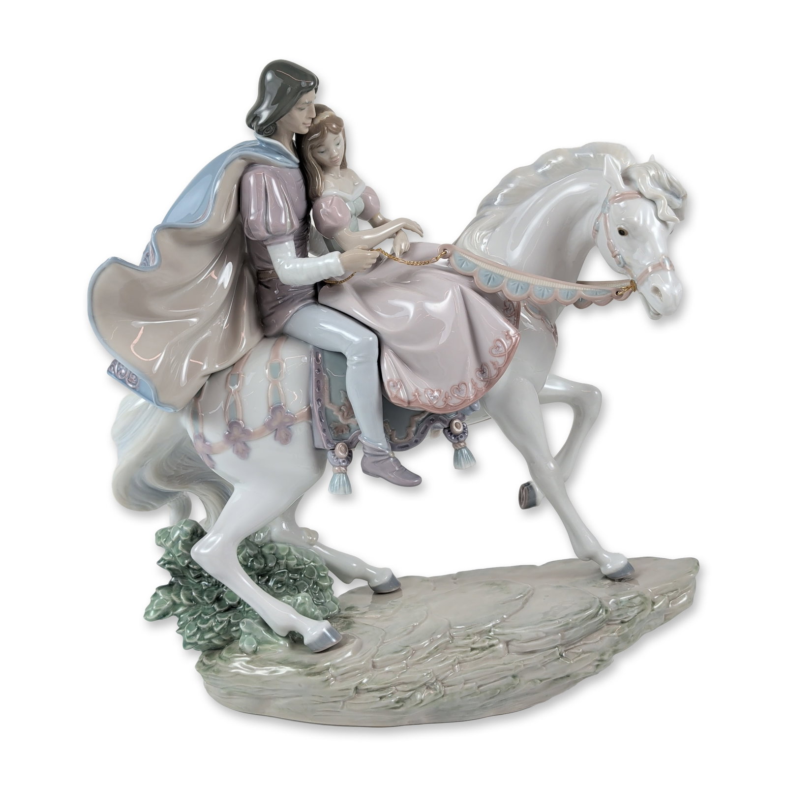 Lladro Love Story Porcelain Figurine: Lladro glazed porcelain figurine, model number 5991, designed by Jose Puche. The sculpture depicts a couple in fantasy-medieval costume riding a rearing white stallion on a rocky terrain base