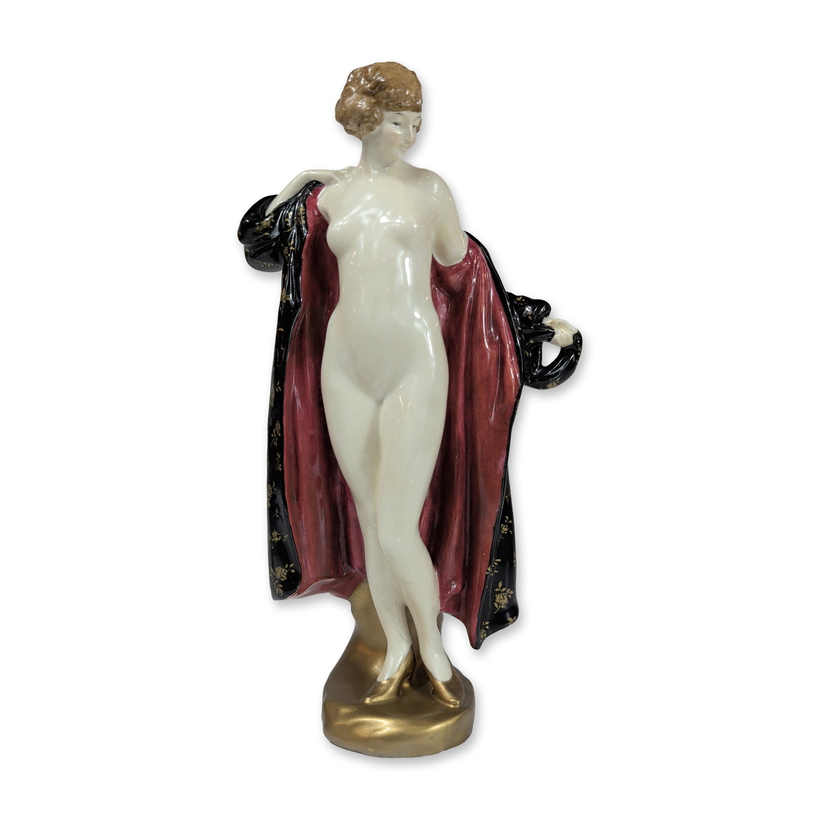 Royal Doulton Porcelain Art Deco Figurine, The Bather HN1238: Designed by Leslie Harradine. The piece depicts a nude female figure draped in a flowing black cloak with a burgundy-red lining and hand-painted gold-gilt floral rose sprigs. The figure stands on a st