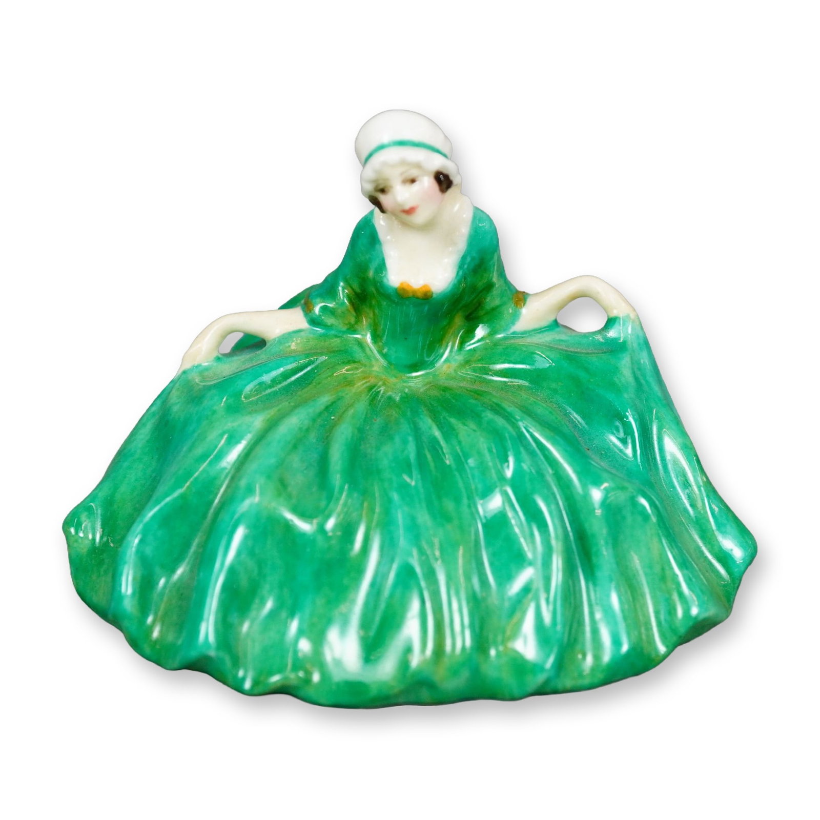 Royal Doulton Colorway Figurine, Polly Peachum: Character from "The Beggar's Opera", the figure depicts a young woman curtsying. She is shown wearing a green gown with ochre accents. Royal Doulton backstamp. Dimensions: 3"L x 2.5"W x 2.25"H Manufac