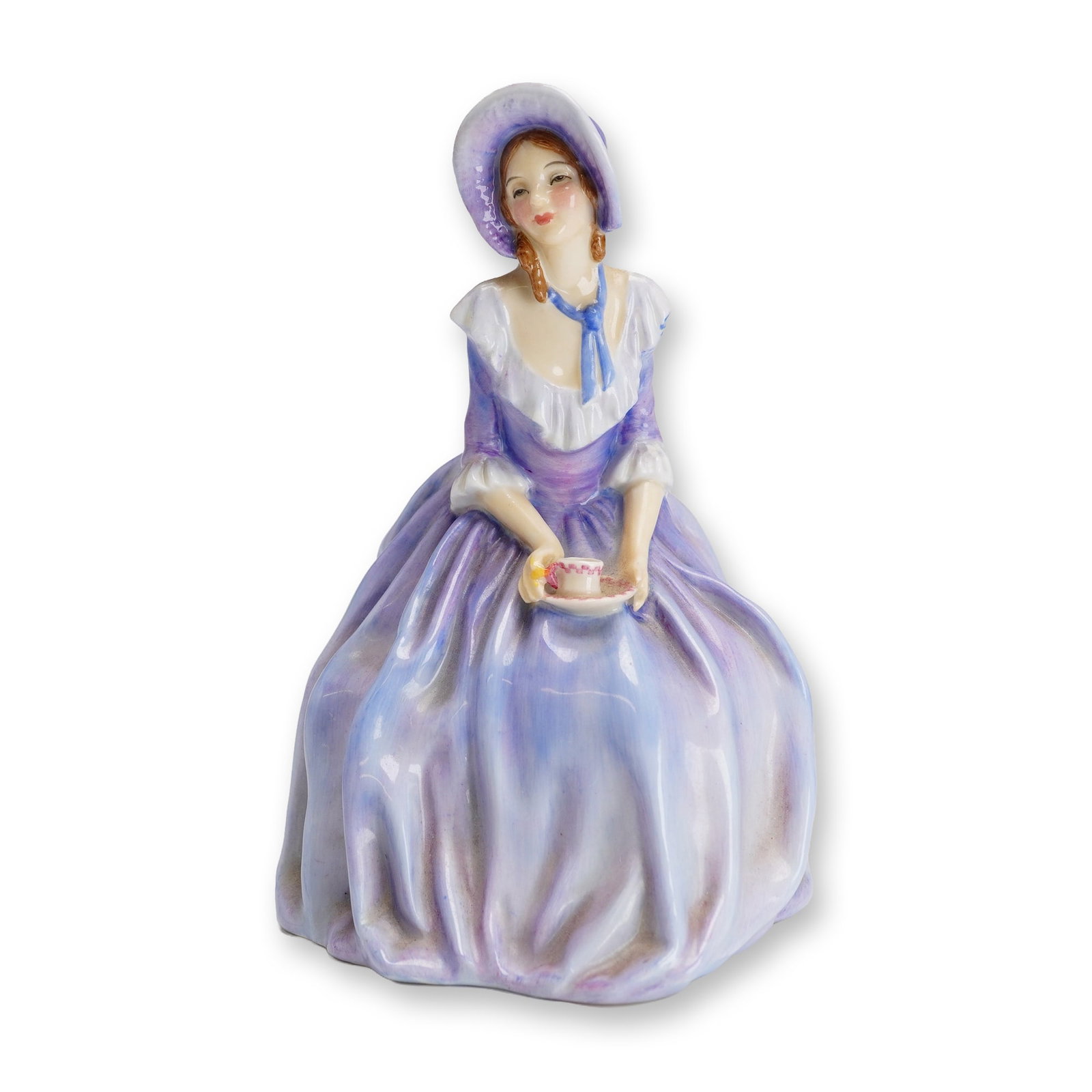 Royal Doulton Bone China Figurine, 4 O'clock HN1760: Part of the Harradine Classics series, designed by Leslie Harradine. This hand-painted lavender figure depicts a lady dressed in a bonnet and gown, enjoying her four o'clock tea. Features Royal Doulto
