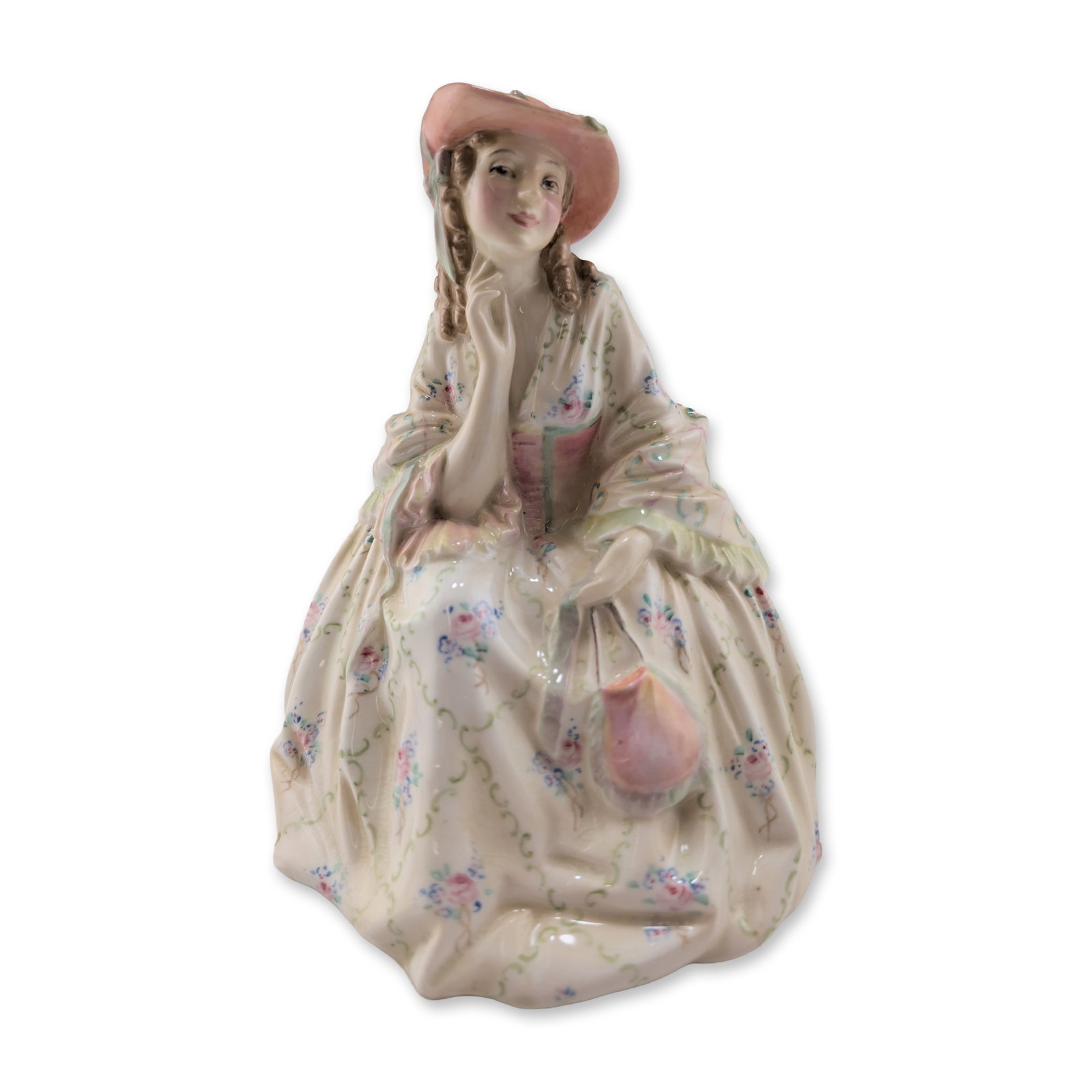 Royal Doulton Porcelain Figurine, Herminia HN1644: Depicting a seated woman in a pink hat and cream-colored dress decorated with hand-painted floral sprigs and green scrollwork. Base features printed Royal Doulton lion and crown mark. 6"W x 7"H 15 oz.