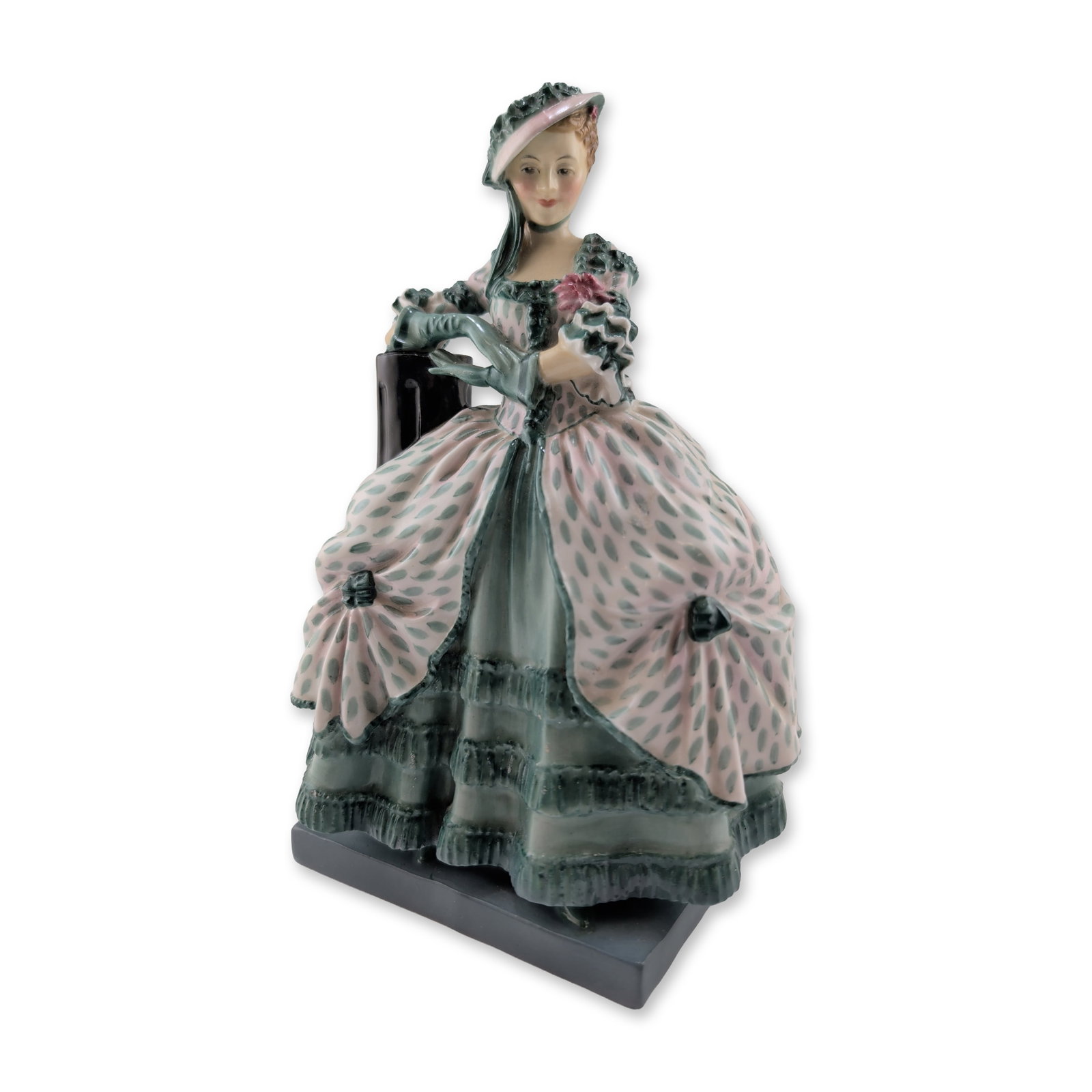 Royal Doulton Porcelain Figurine, Kate Hardcastle HN1734, Rare Version: The figure is modeled in 18th-century style attire, featuring a voluminous tiered and ruffled skirt in pale seafoam green with a repeating pink teardrop motif. She is depicted standing next to a dark 