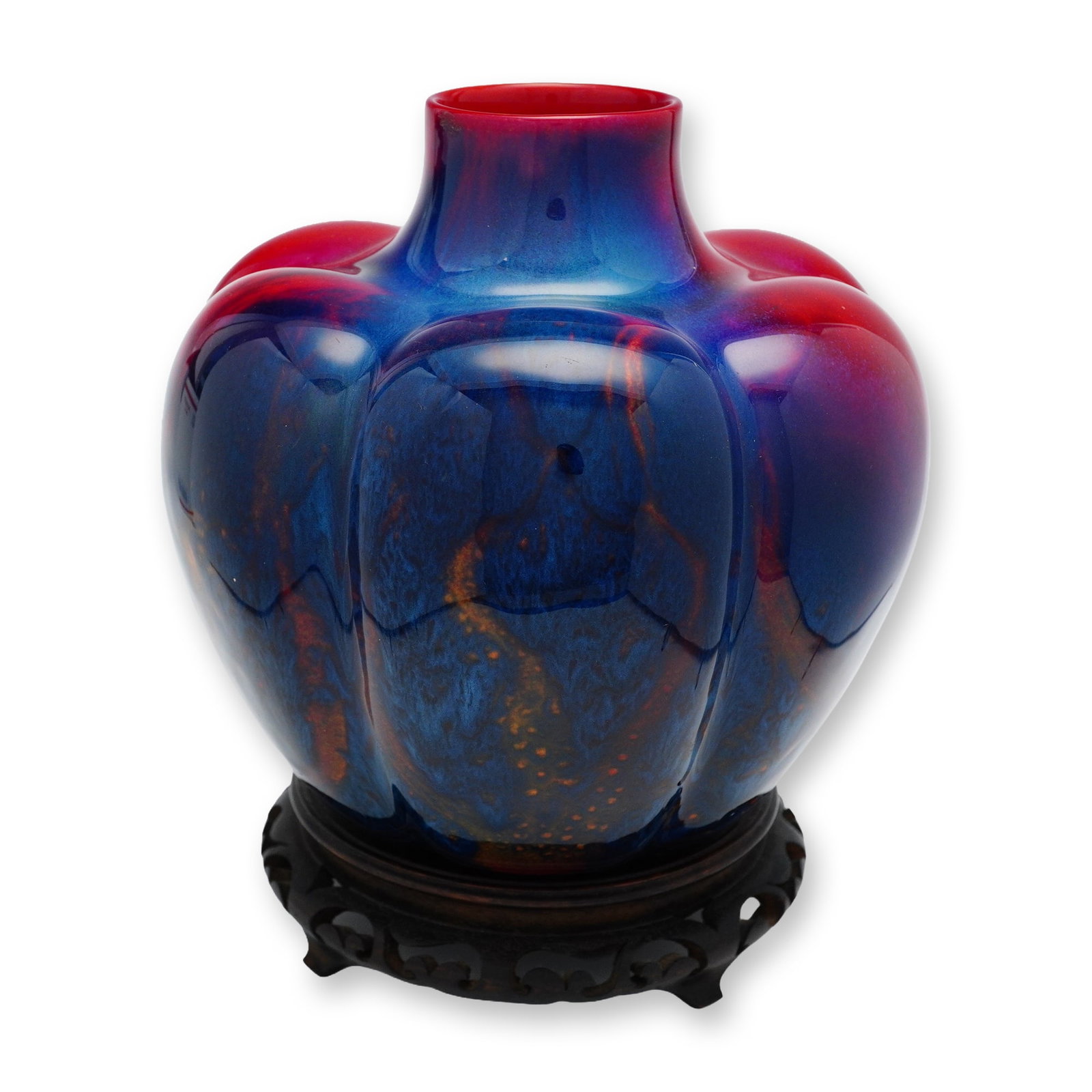 Royal Doulton by Fred Moore Sung Flambe Pumpkin Vase with Base: A pumpkin-form vase with a red fired glaze, accented by mottled blue and yellow hues. Includes base. Bearing Royal Doulton Flambe backstamp and Sung mark. This item has a base included. Artist: Fred M