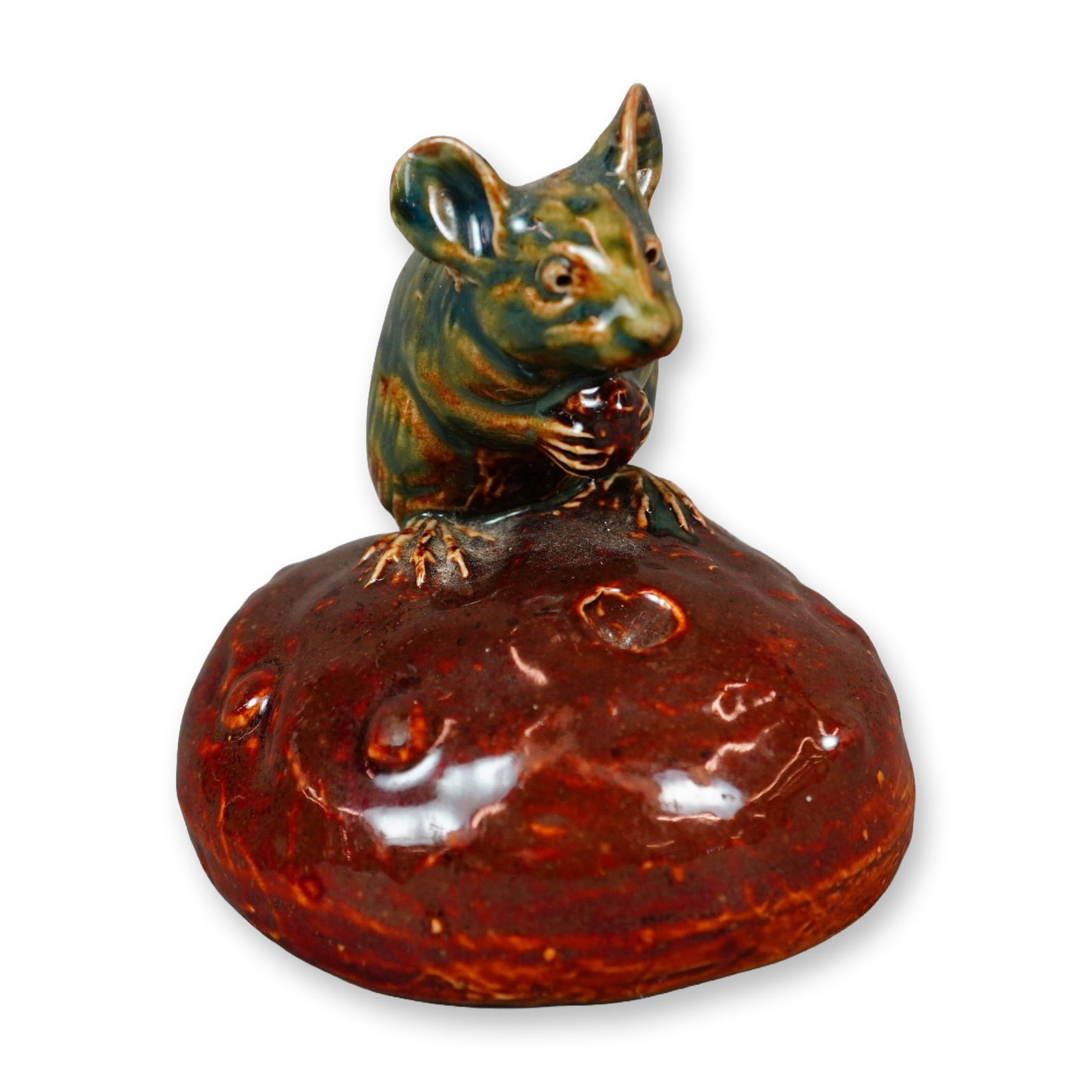 Doulton Lambeth by George Tinworth Stoneware Figurine, Currant Bun: Stoneware figure depicting an endearing bluish-grey mouse with brown accents, seated on a bun while eating a currant. Features a GT impressed monogram and an impressed Royal Doulton rosette mark. Arti