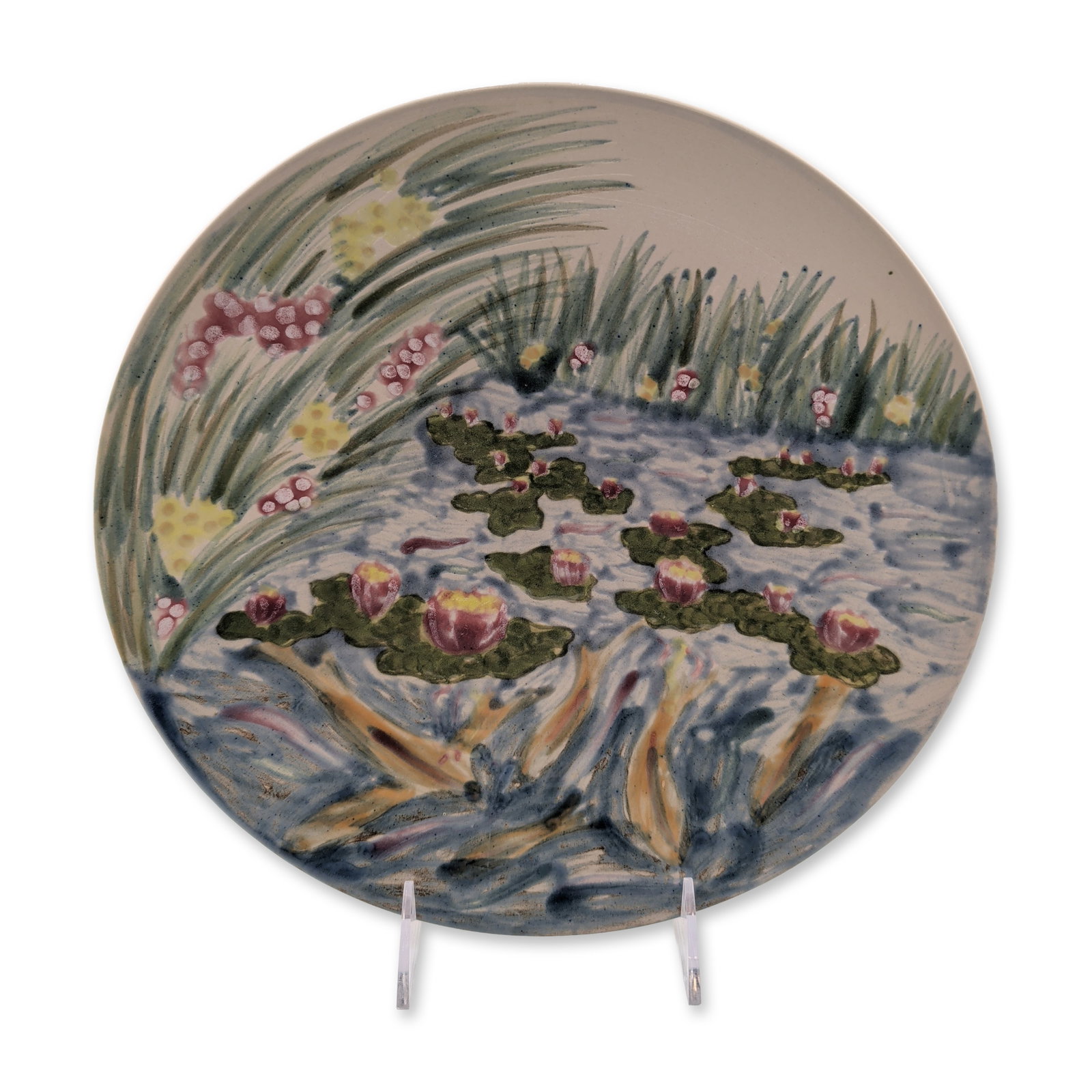 Cobridge Stoneware Water Lily Cabinet Plate: Hand-painted stoneware featuring an impressionistic aquatic scene with pink and yellow water lilies, blue swirling water, and green reeds. The decoration is applied in a heavy slip technique resulting