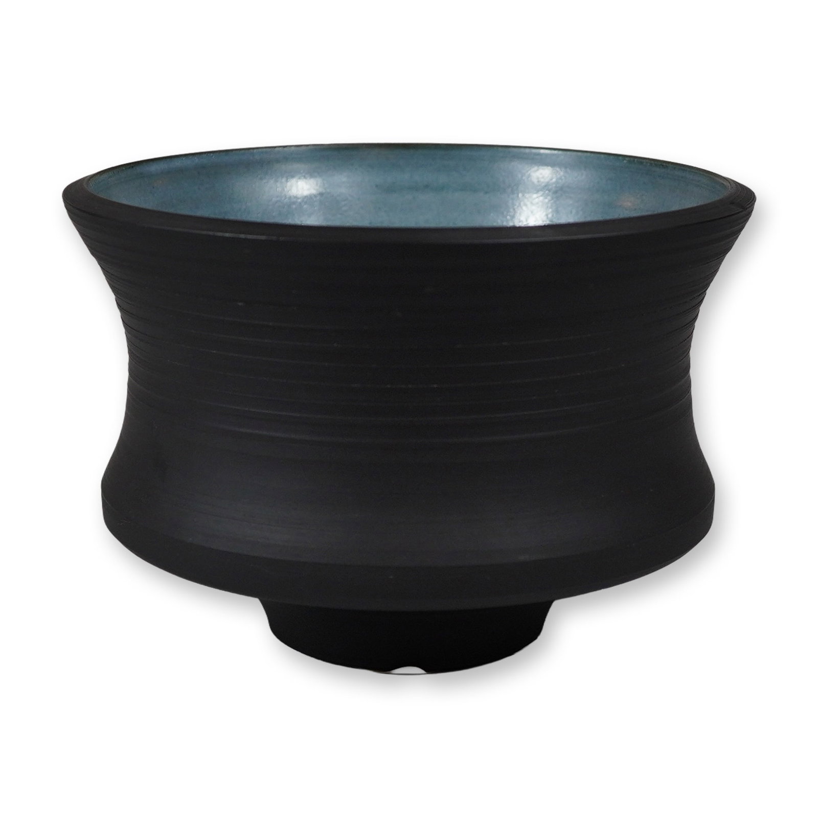 Studio Pottery Footed Vessel with Matte Black and Turquoise Glazes: This studio pottery vessel is a stoneware piece featuring a distinctive thrown form with a wide, flared rim that tapers to a constricted waist and expands into a bulbous lower body. It sits on a short