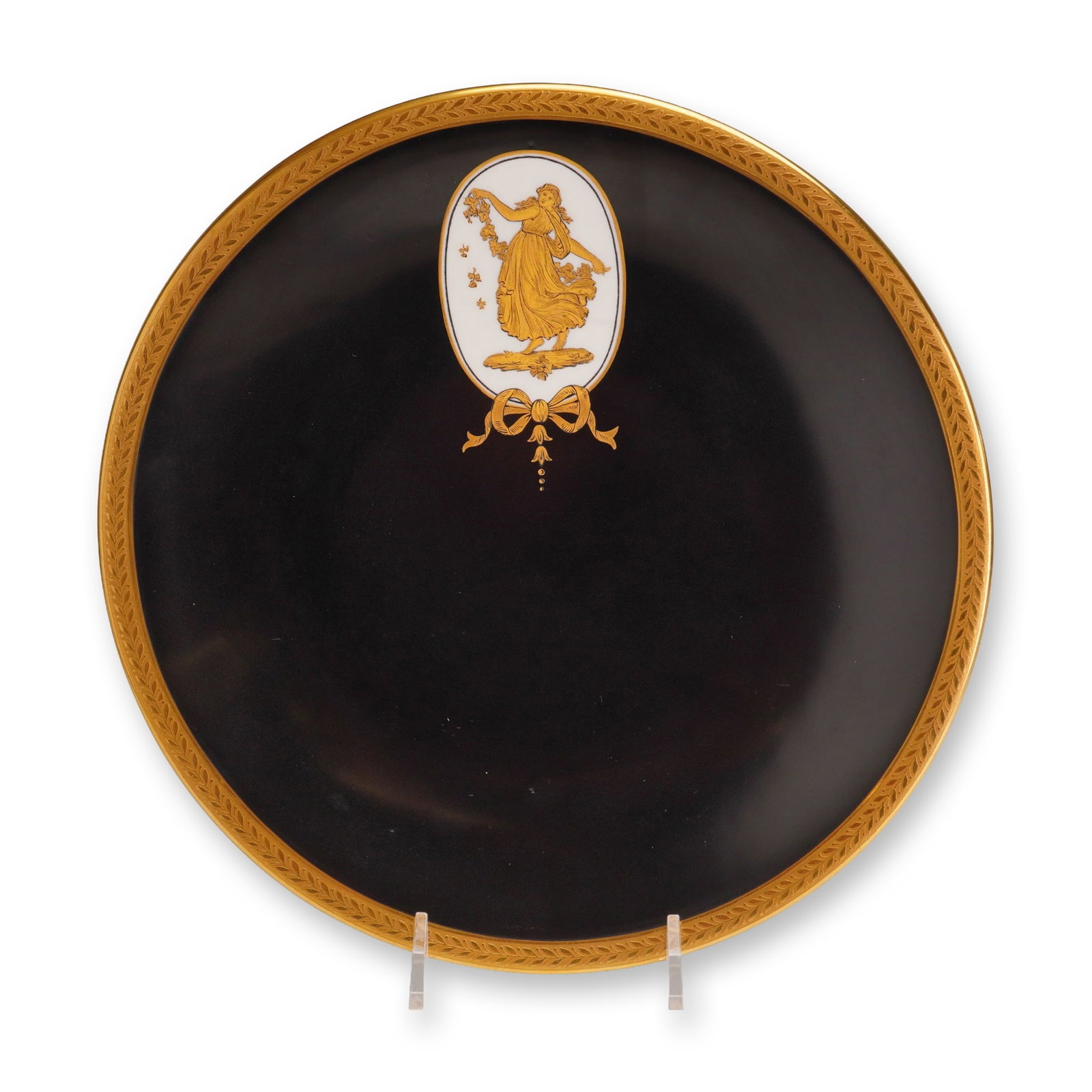 Wedgwood Gilded Black Basalt Porcelain Cabinet Plate: The plate features a matte black ground in the style of black basalt, contrasted by a white translucent body visible on the reverse. The central decoration consists of an oval white medallion containi