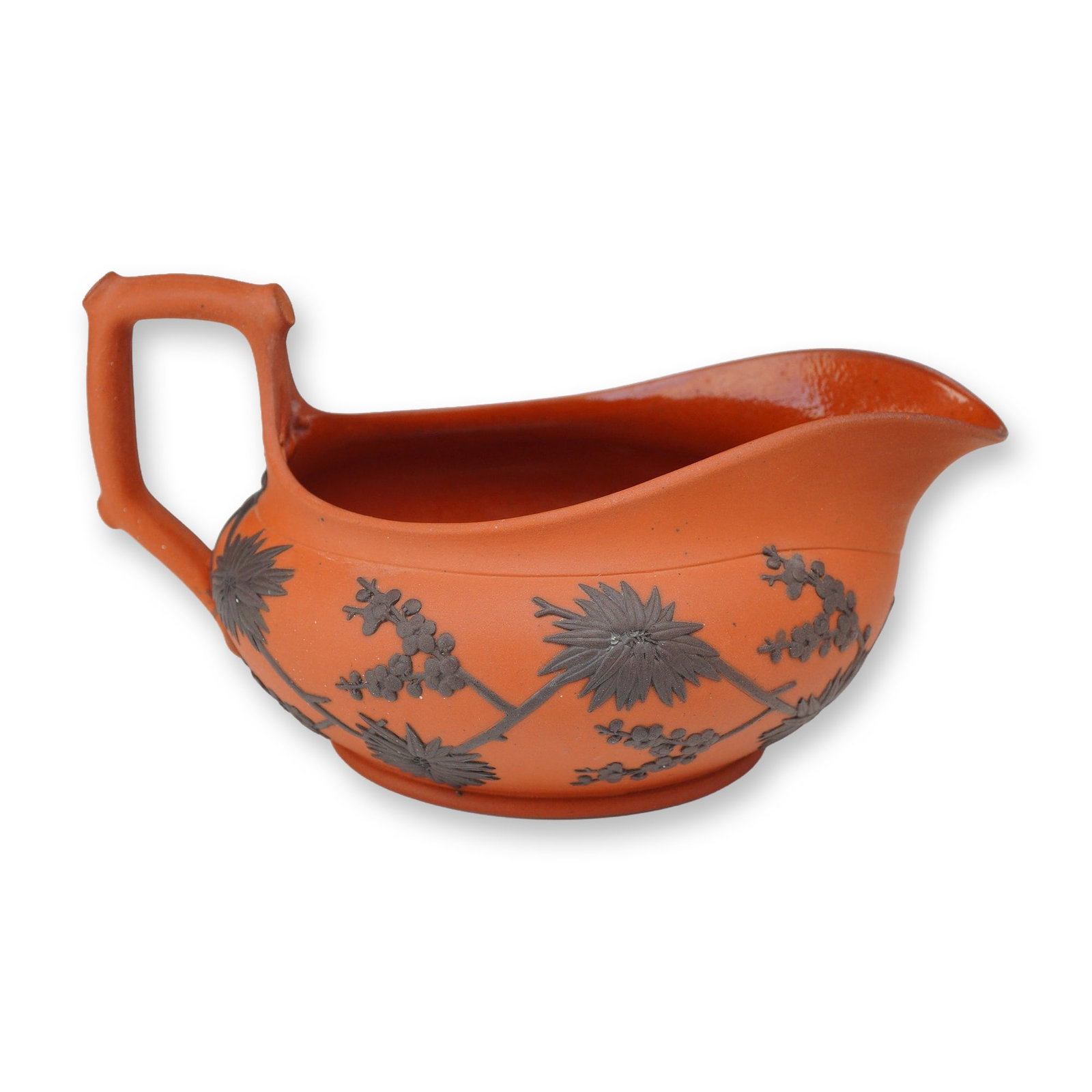 Wedgwood Rosso Antico and Black Basalt Sprigged Sauce Boat or Creamer: A Wedgwood Rosso Antico sauce boat or creamer featuring a low-profile, oval-bodied form. The piece is constructed from fine-grained red stoneware, known as Rosso Antico, with a matte, unglazed exterio
