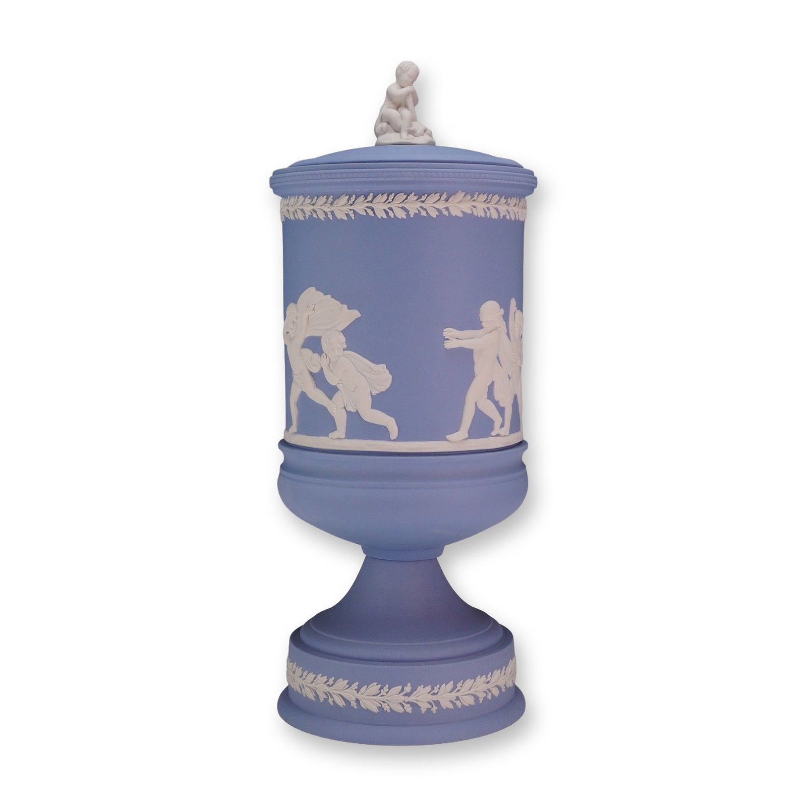 Wedgwood Blue and White Jasperware Lidded Pedestal Jar: This cylindrical pedestal jar is crafted from blue and white Wedgwood jasperware, an unglazed stoneware featuring white bas-relief decorations. The body of the jar depicts various scenes of frolicking
