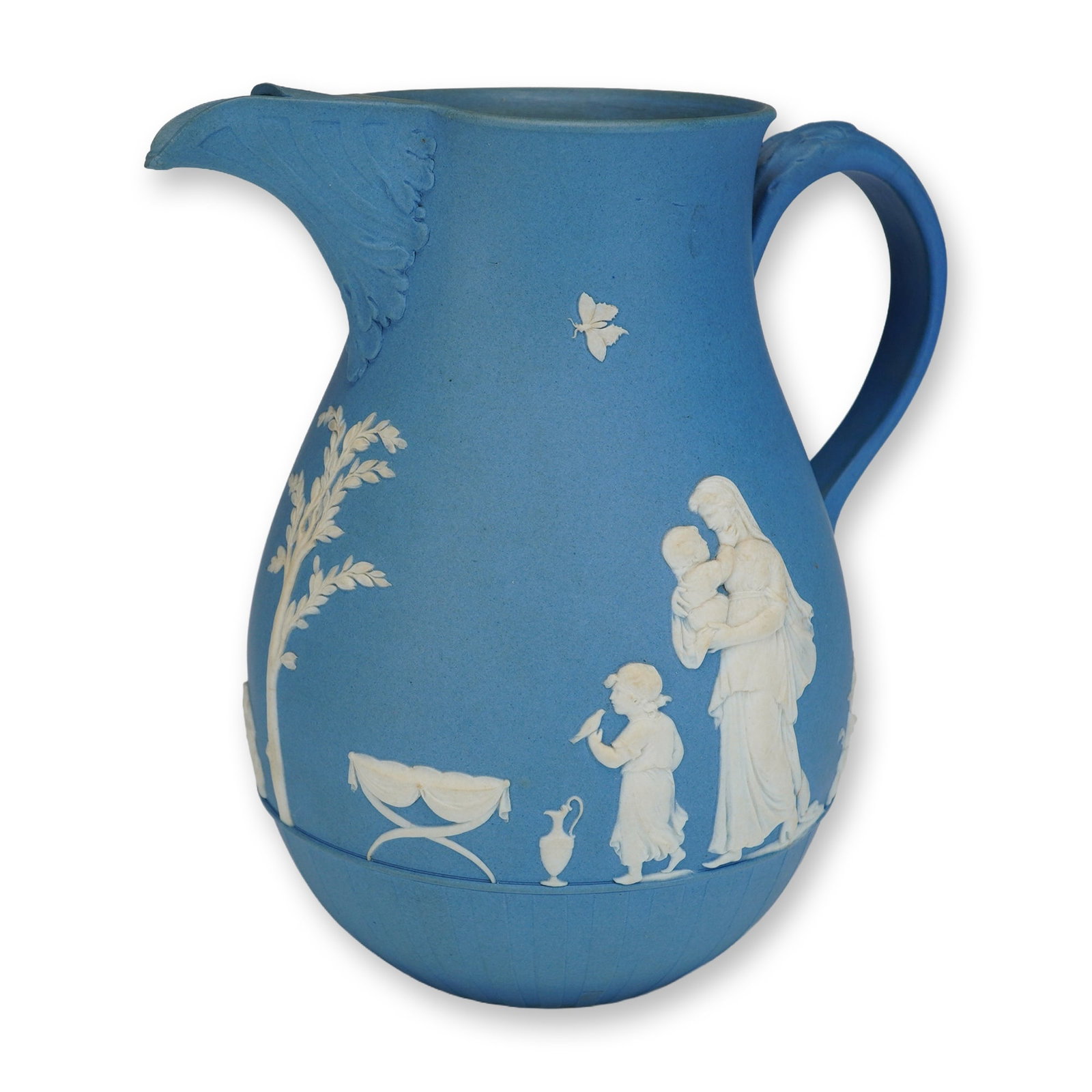 Wedgwood Blue Jasperware Pitcher with Neoclassical Relief Scenes: A Wedgwood blue jasperware pitcher featuring a matte blue stoneware body with applied white relief decorations. The pitcher is designed with a bulbous body, a wide neck, and a pinched leaf-molded spou
