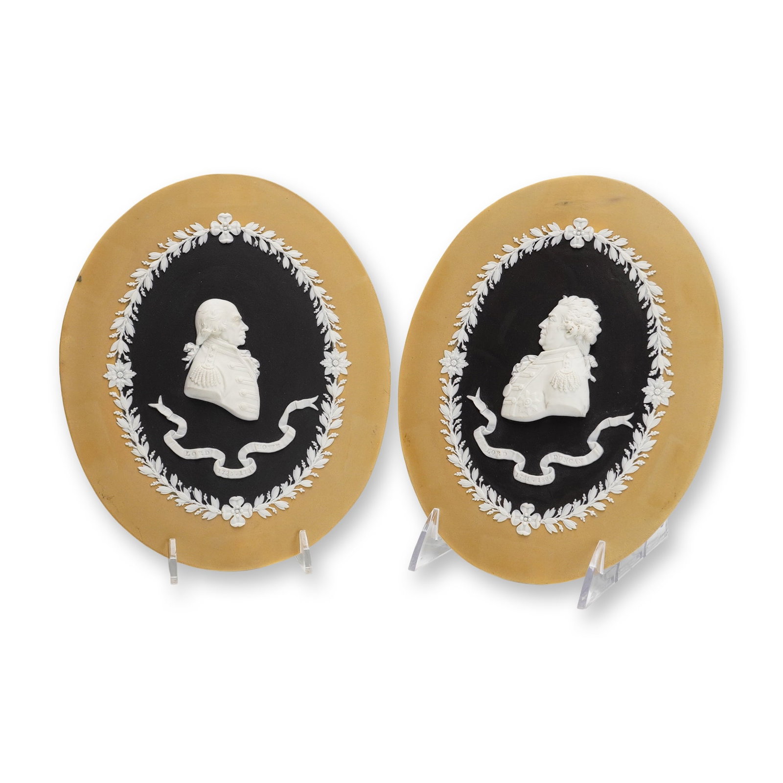 A Pair of Wedgwood Tri-Color Jasperware Portrait Medallions of Admiral Lord Howe and Admiral Lord: This pair of Wedgwood tri-color jasperware medallions is crafted from unglazed stoneware. Each oval plaque features a central profile bust in white sprigged relief set against a black dipped central f